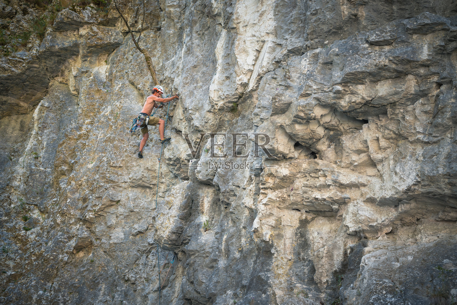 一个登山者爬上山墙，朝着山顶走去。照片摄影图片