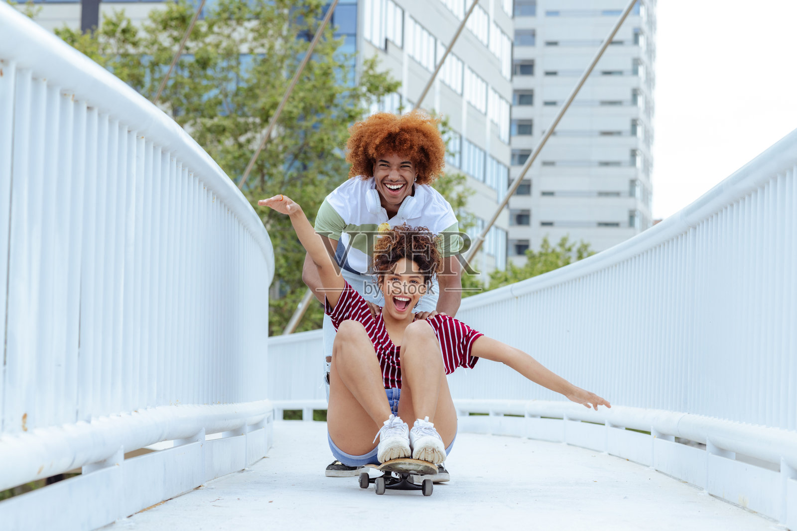 一对快乐的夫妇在城市里玩滑板照片摄影图片