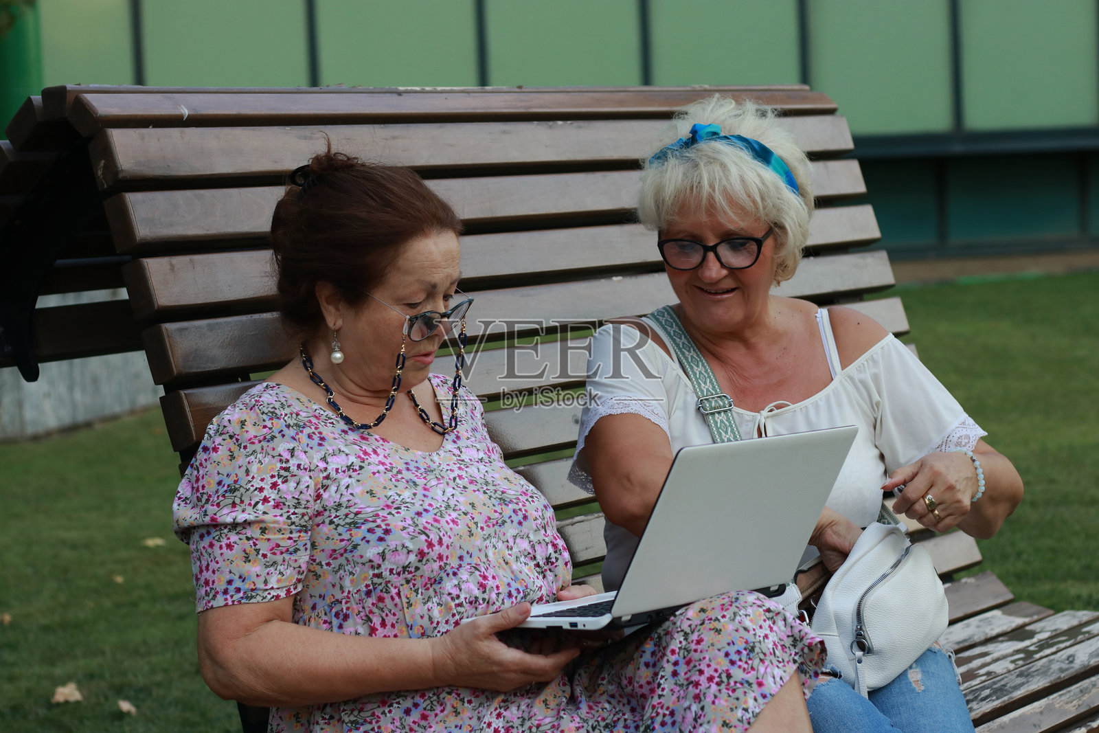 一对老年夫妇在公园里使用科技设备照片摄影图片