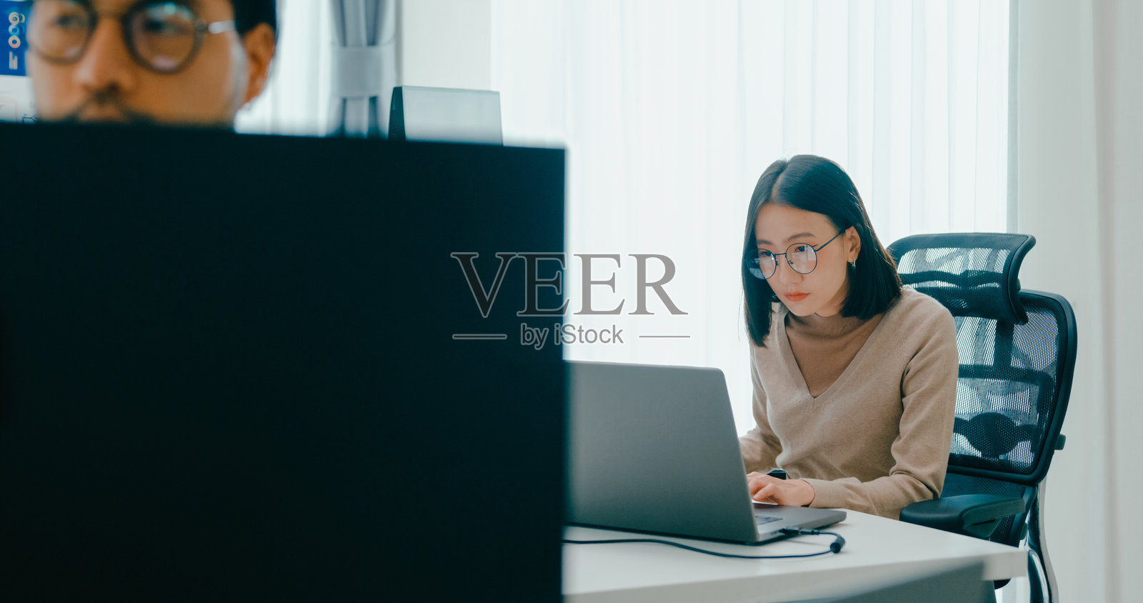 亚洲男性和女性自由职业者在桌面电脑上使用智能程序、视频游戏、终端与编程语言、用户界面、设计师和大数据中心进行输入和写作提示的AI机器人。照片摄影图片