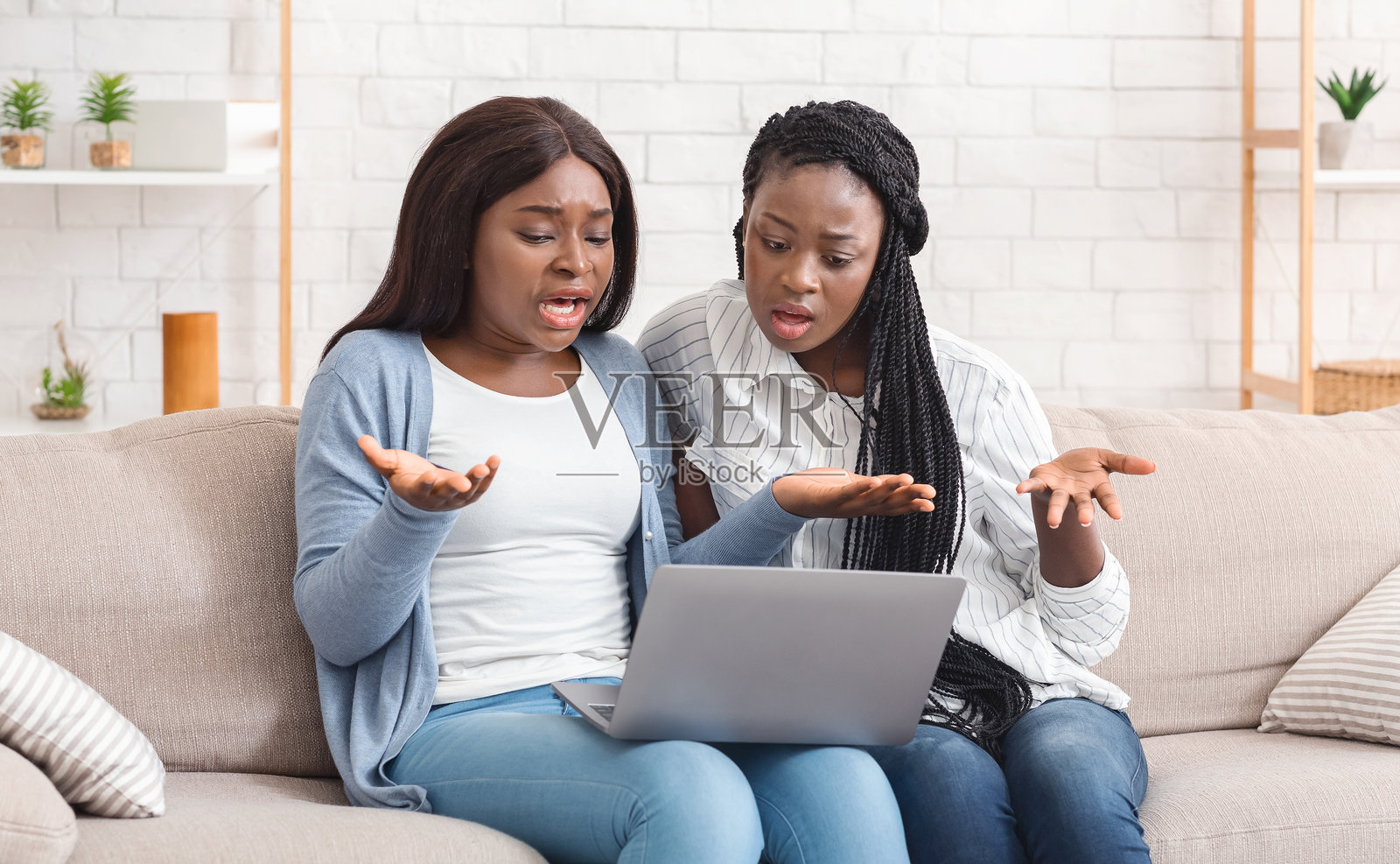 两个失望的黑人女性朋友在家里面对笔记本电脑的问题照片摄影图片