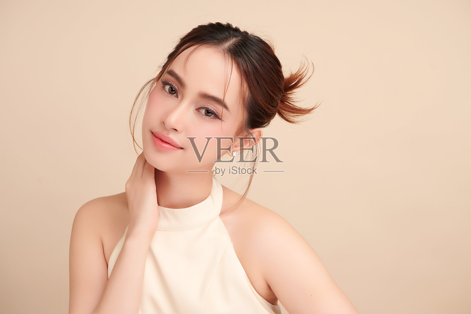 美丽的年轻亚洲女性，肤色洁净清新，背景为米色，面部护理，面部治疗，美容学，美容与水疗，亚洲女性肖像。照片摄影图片