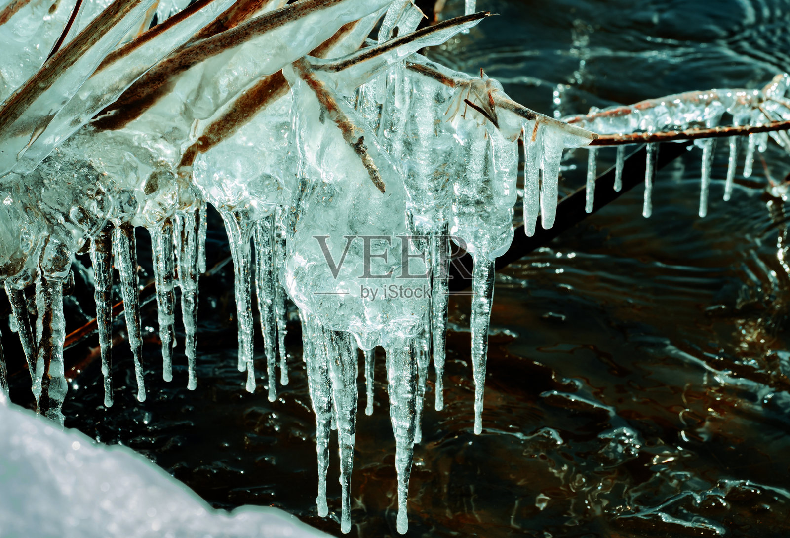 融化的冰块和冰柱躺在海岸上照片摄影图片