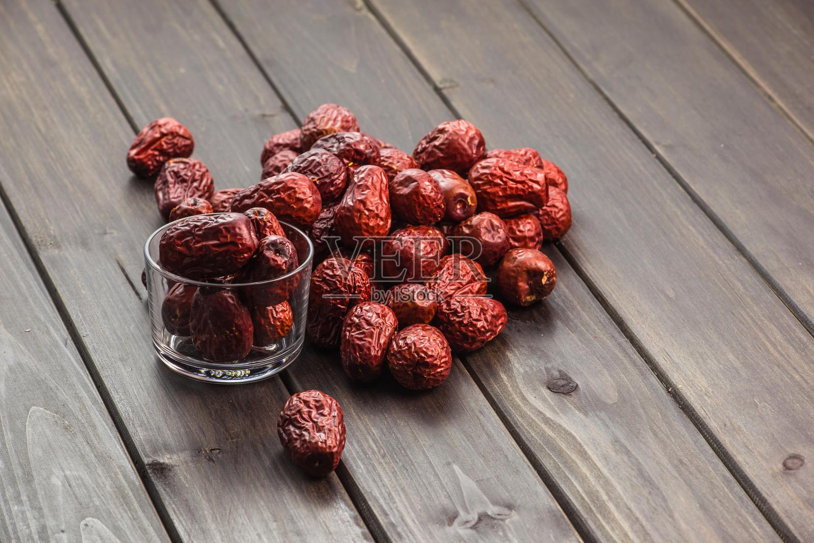 干枣散落在木桌上照片摄影图片