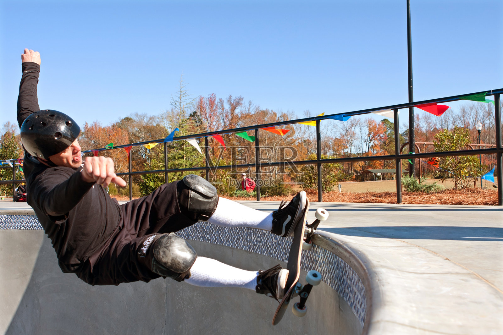 资深滑板手在新滑板公园的大碗上滑行照片摄影图片