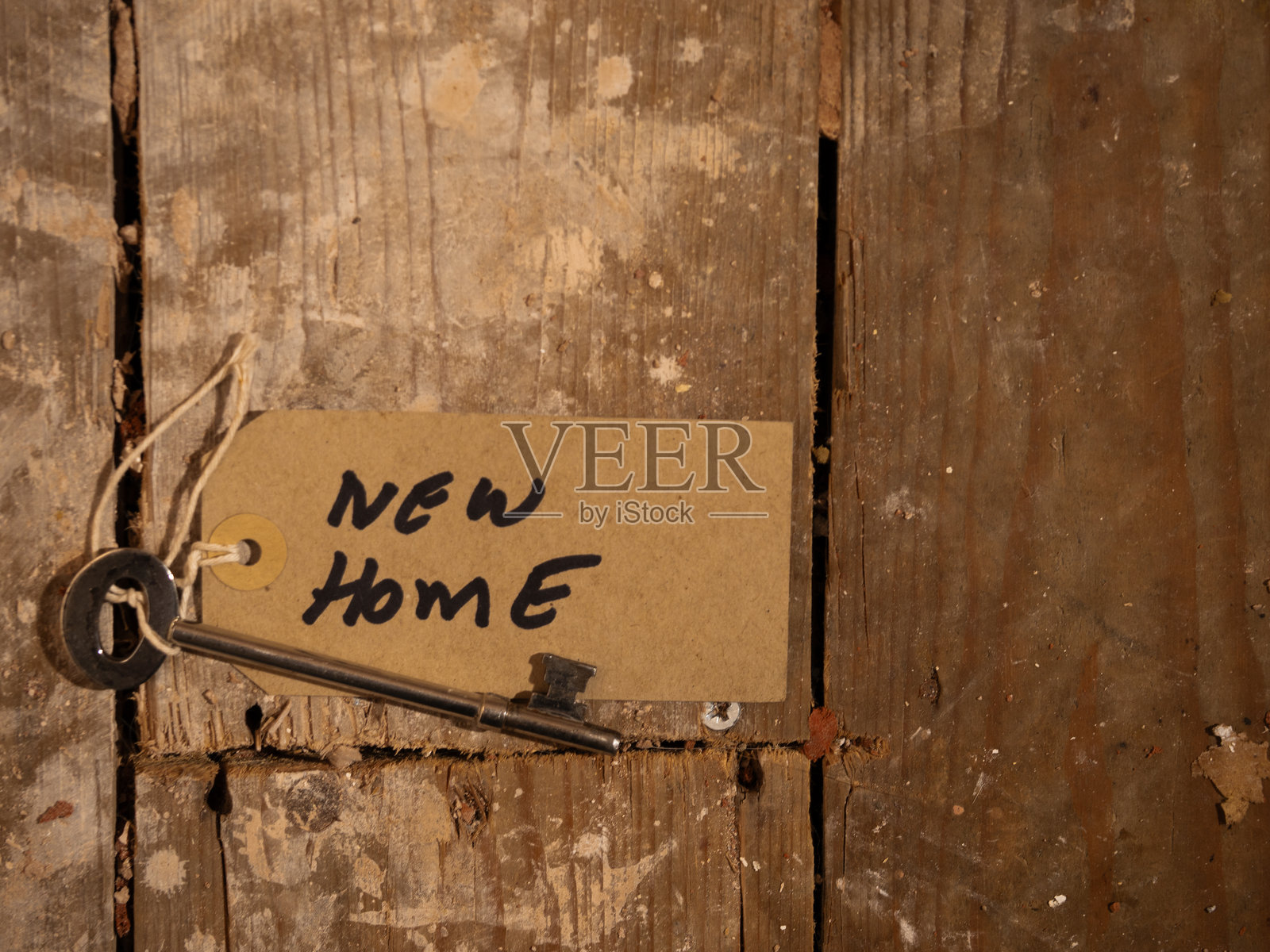 新家钥匙放在尘土飞扬的破旧木地板上照片摄影图片