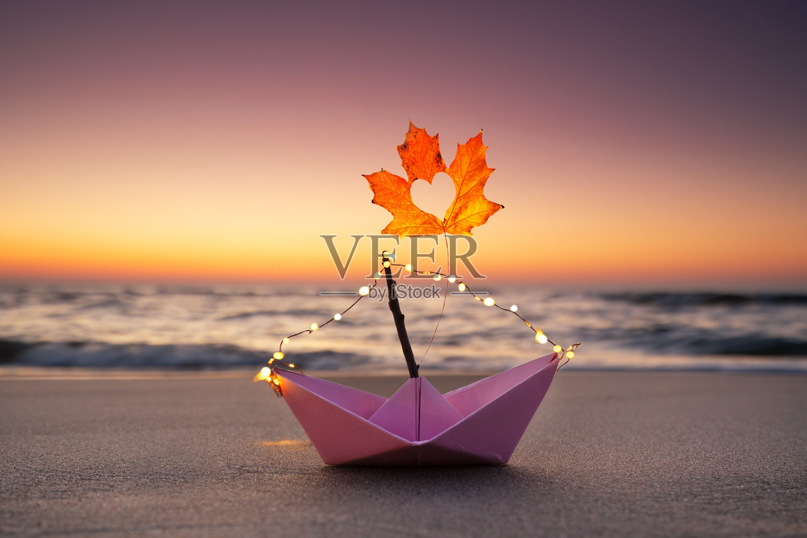 秋天的叶子在纸船上照片摄影图片