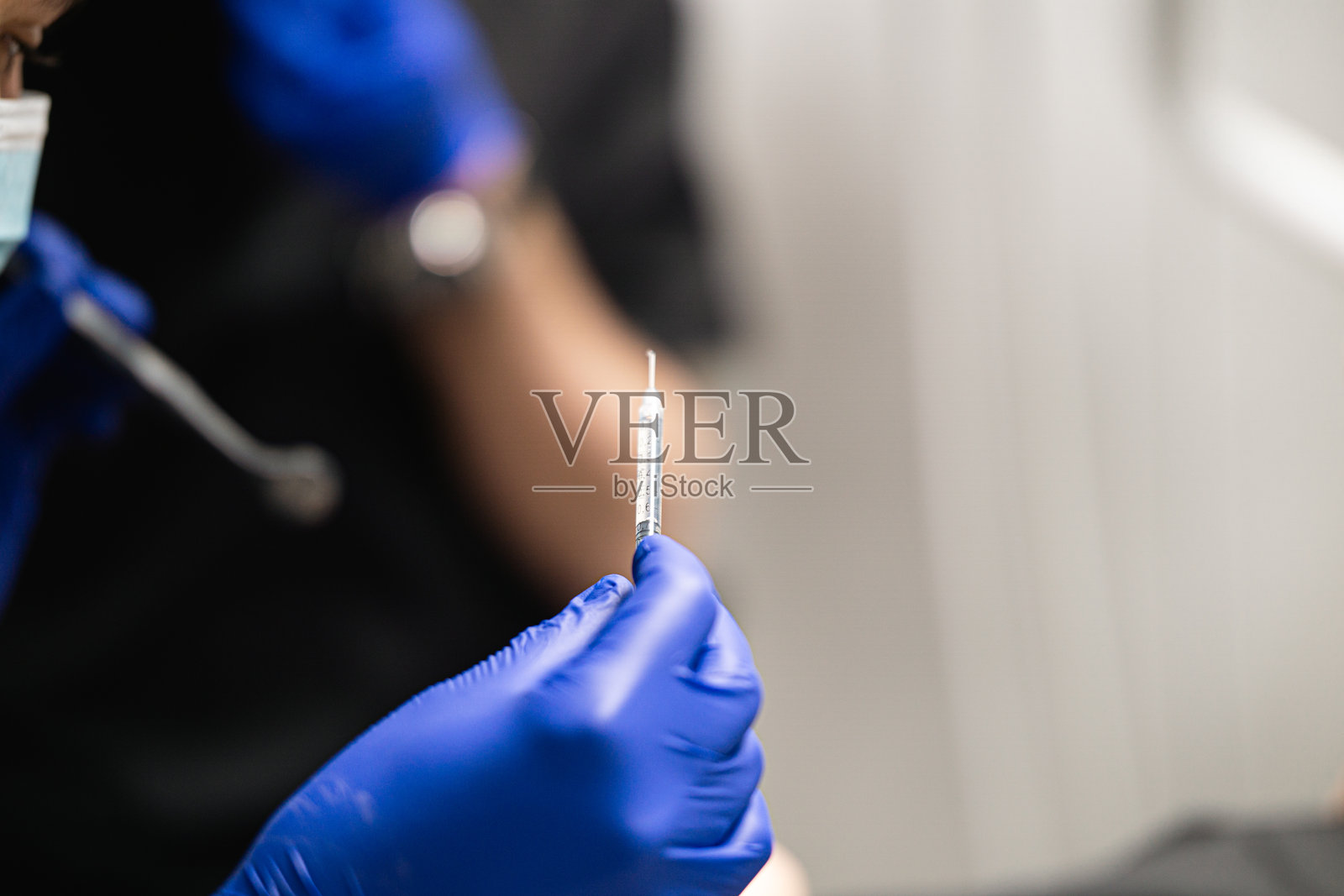 医生手持注射器，准备给病人注射。照片摄影图片