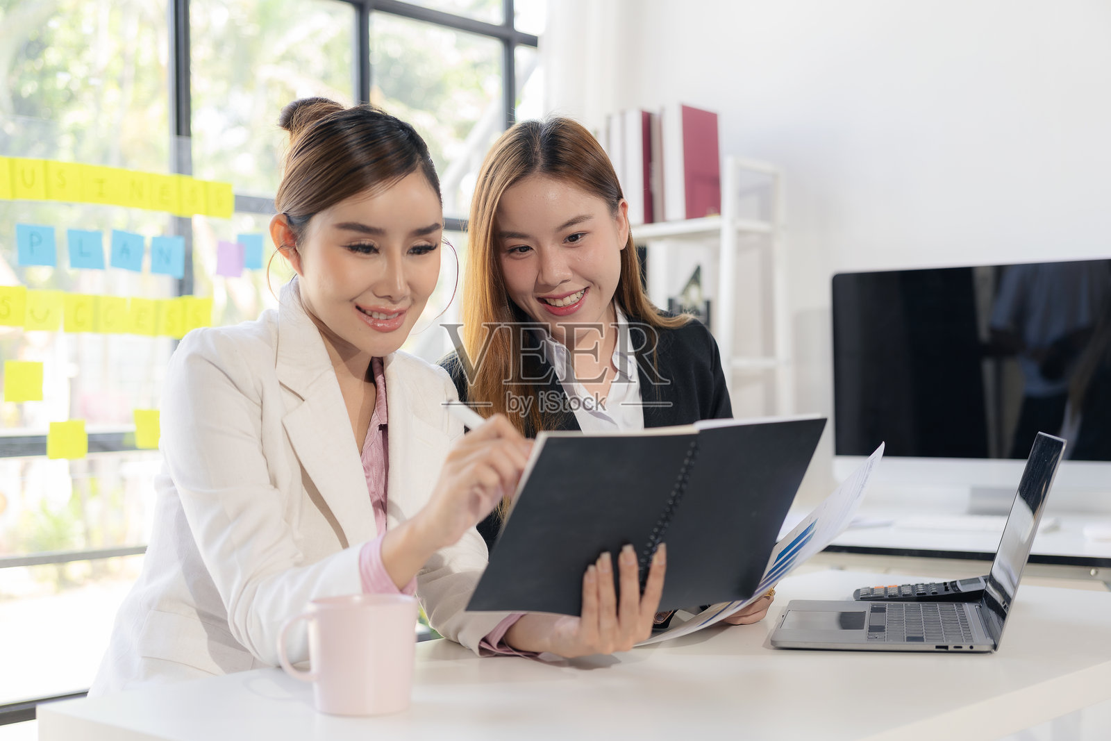 两位女性的交谈，讨论，致力于新的项目创意。分析市场营销计划和商业投资，以确保成功。照片摄影图片