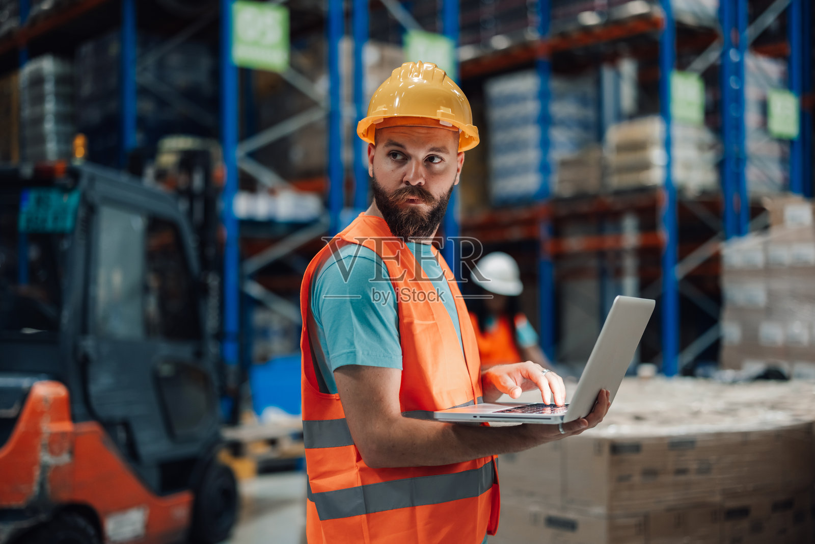 仓库工人在配送中心使用笔记本电脑检查库存照片摄影图片