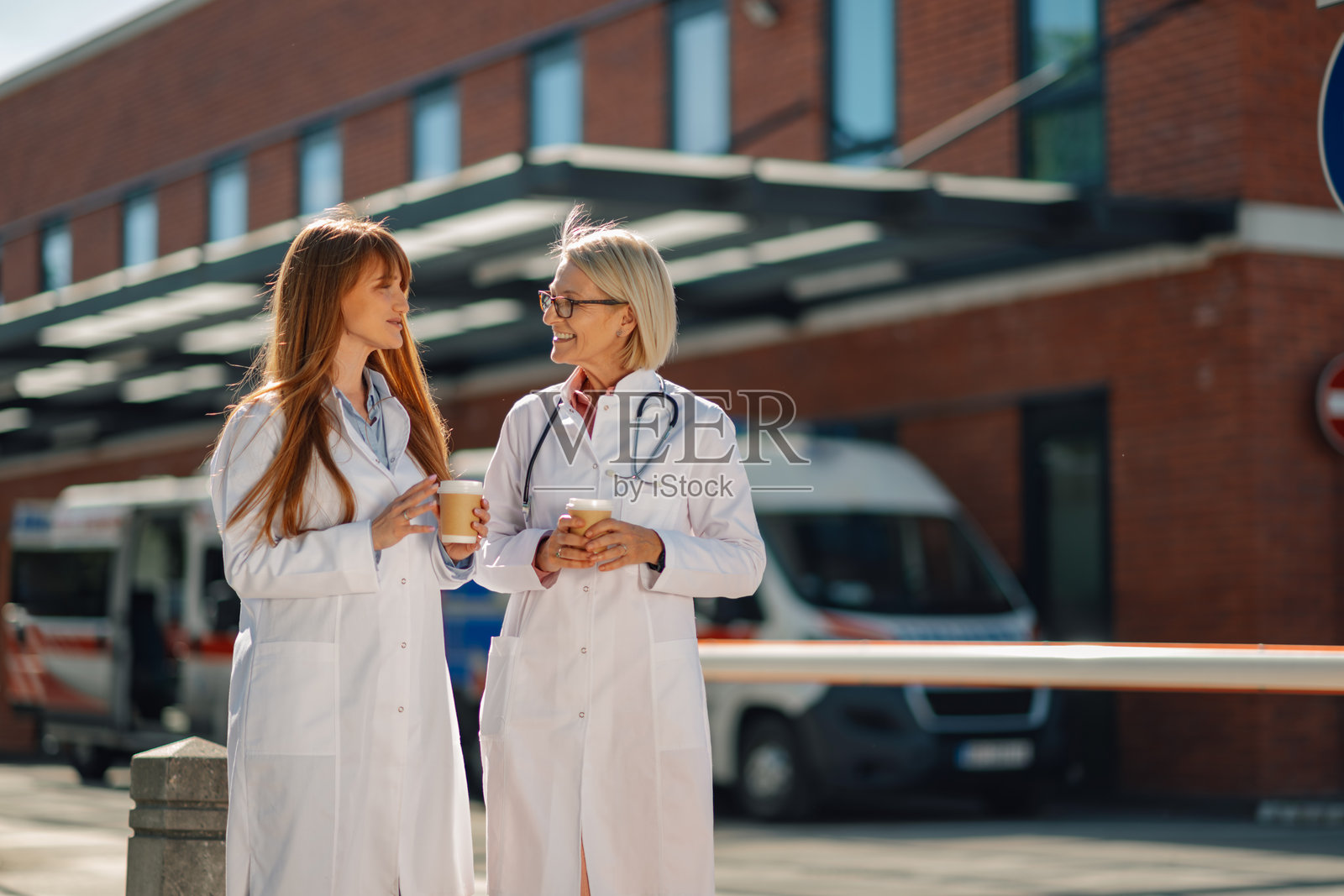 两位女医生在医院外休息喝咖啡照片摄影图片