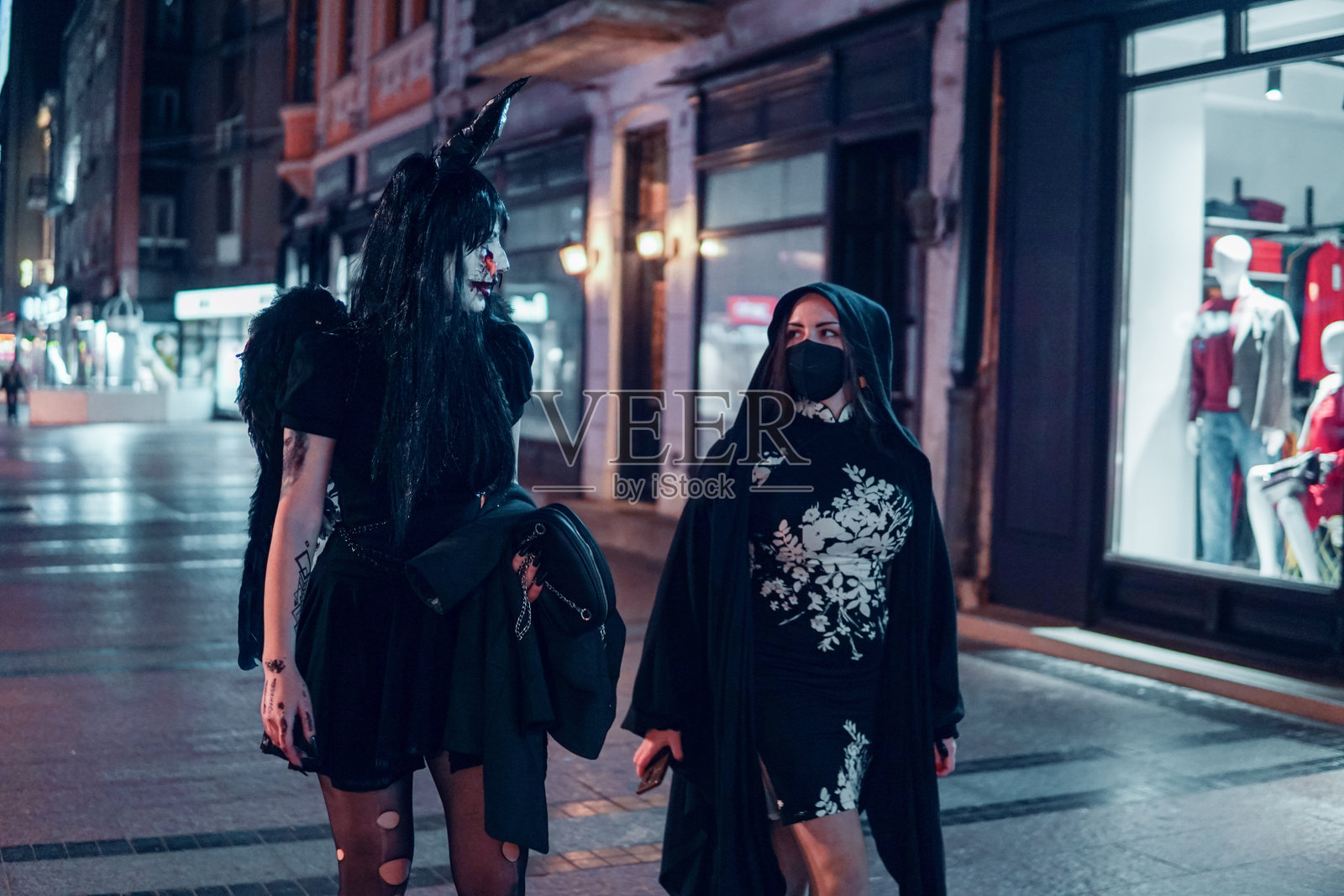 城市中穿着万圣节服装的女性前往派对照片摄影图片