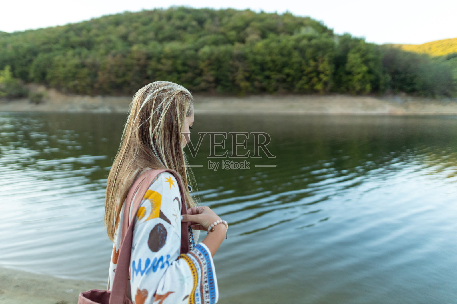 美丽的女性在城市短途旅行中欣赏湖泊，享受美丽的自然。周末时光。照片摄影图片