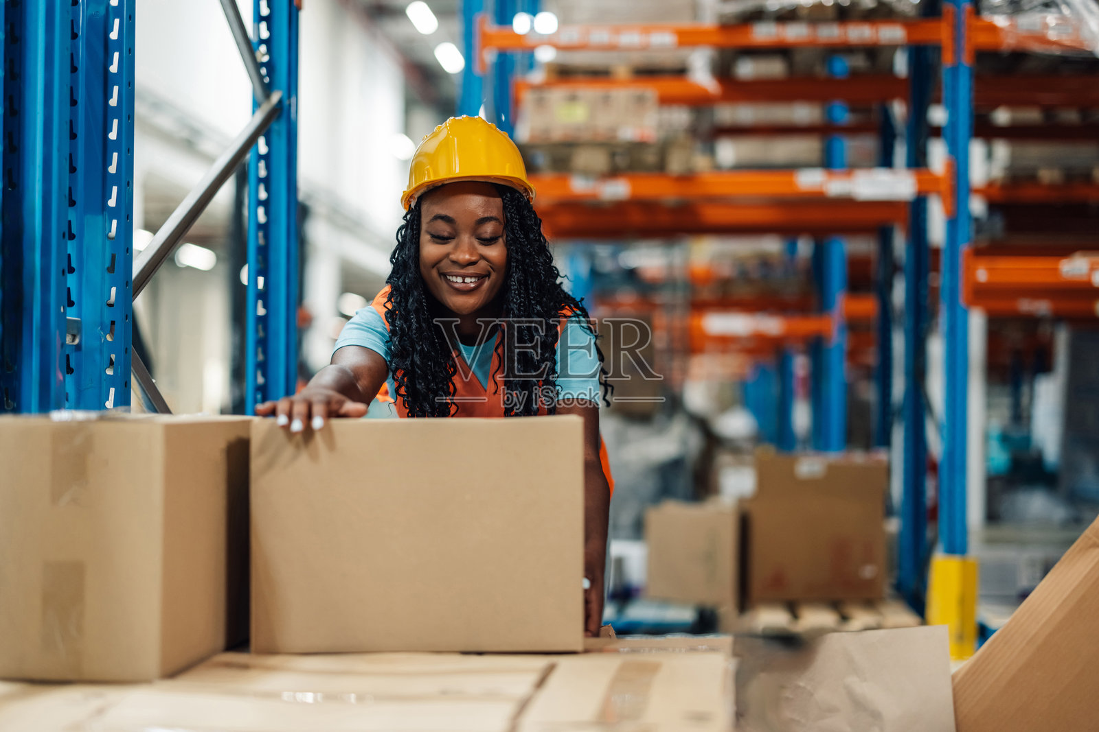 女性仓库工人在检查货架上的纸箱照片摄影图片