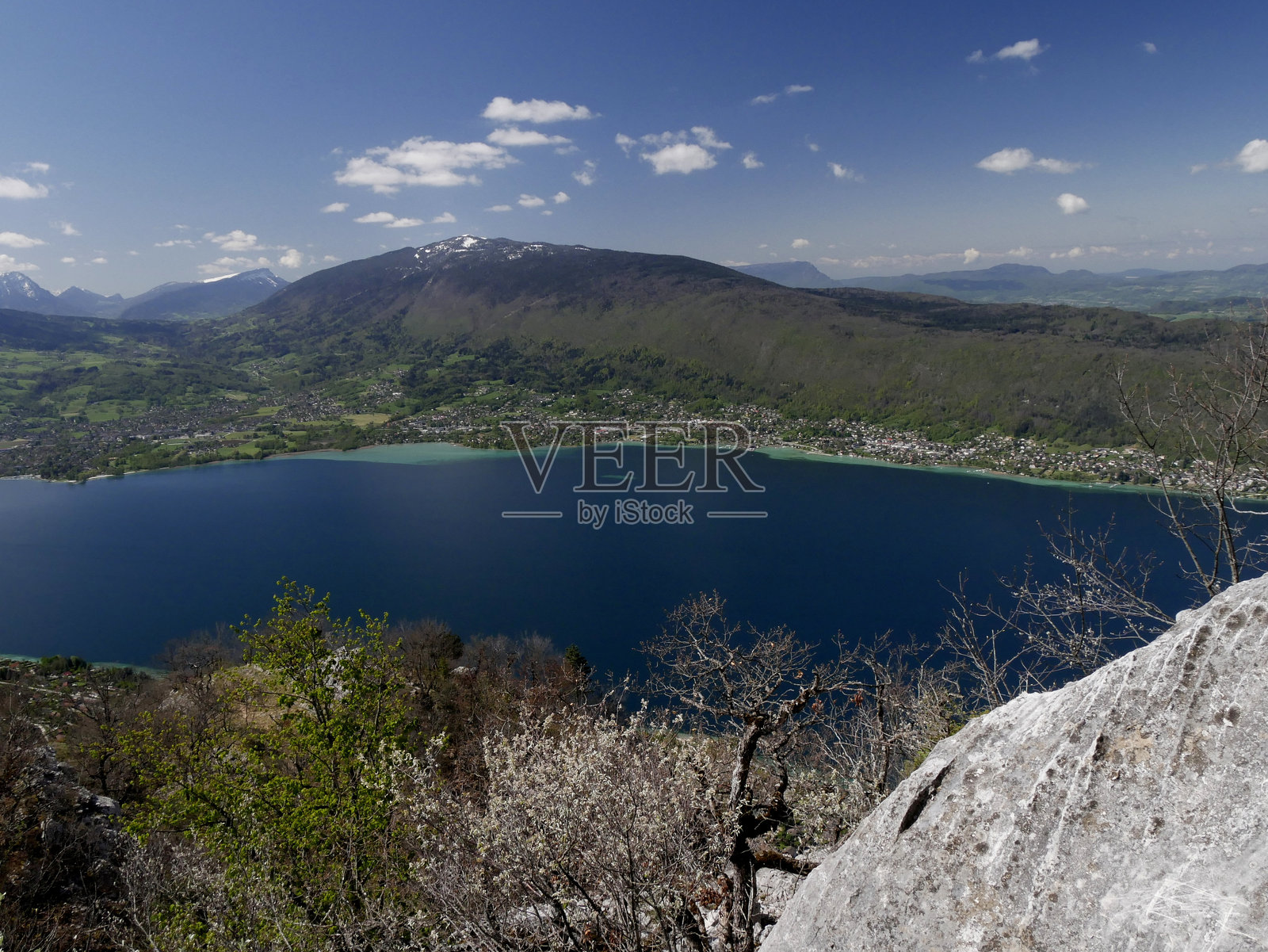 蒙巴朗山上空的全景，安纳西湖及周围的塞姆诺兹阿尔卑斯山和村庄，春季阳光明媚。照片摄影图片