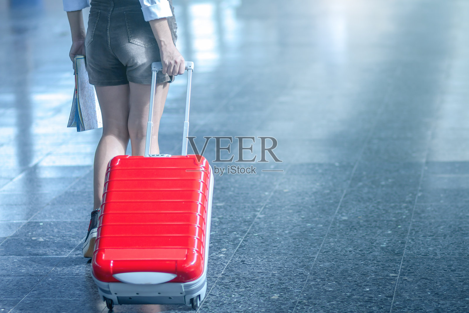 女性下半身拖着行李在地板上行走照片摄影图片