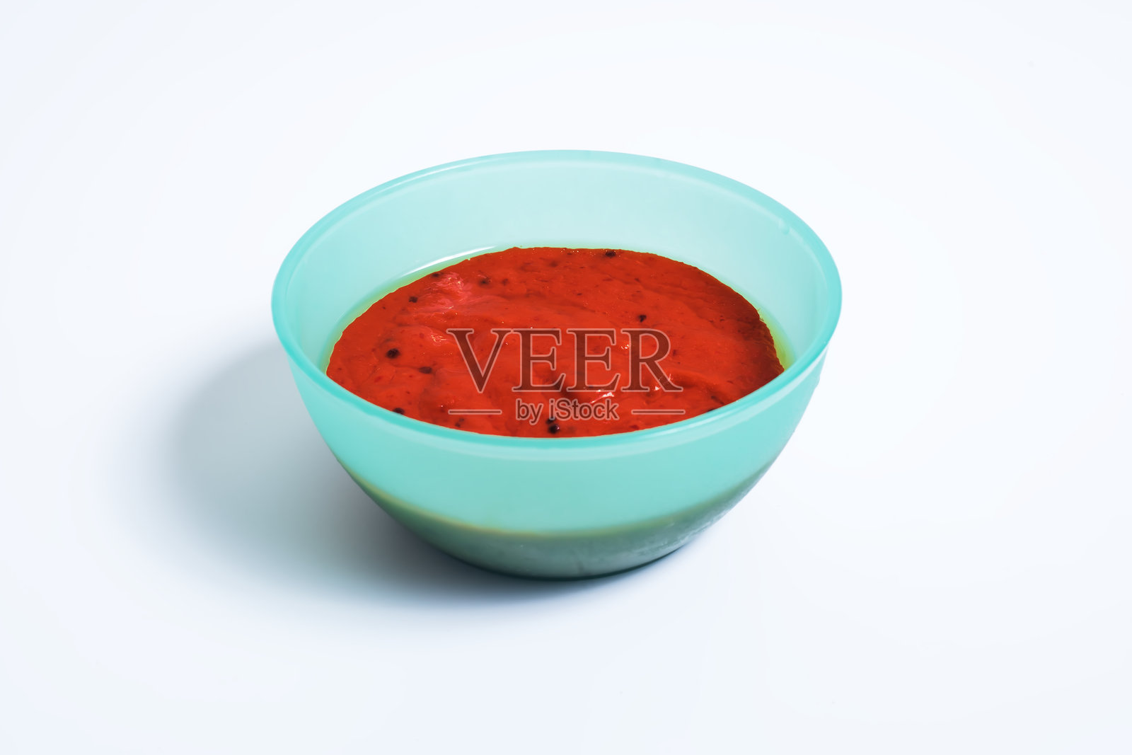 白色背景上的碗里盛着辣味辣椒酱。照片摄影图片