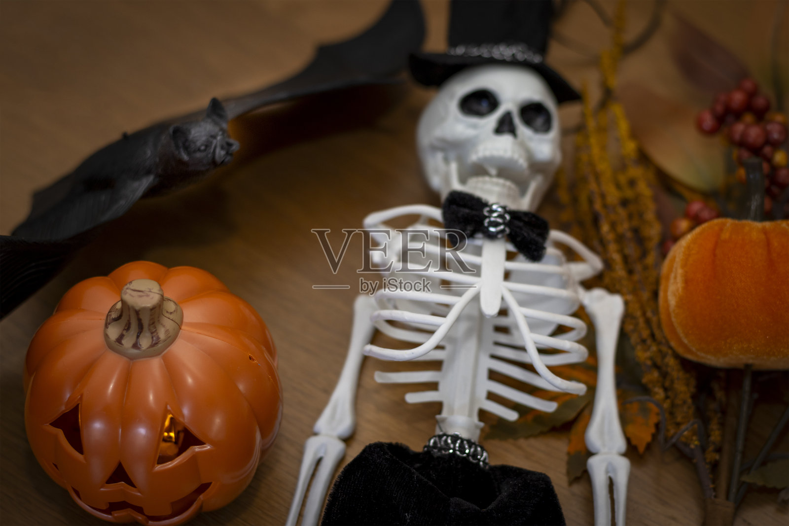 万圣节背景：南瓜、蝙蝠和戴着帽子及领结的骷髅照片摄影图片