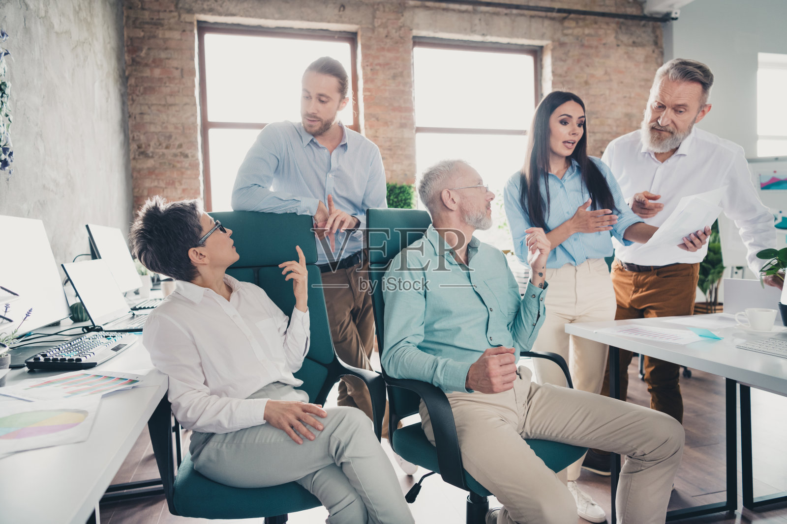 团队合作的人们在现代办公室的舒适阁楼房间内讨论文件工作照片摄影图片