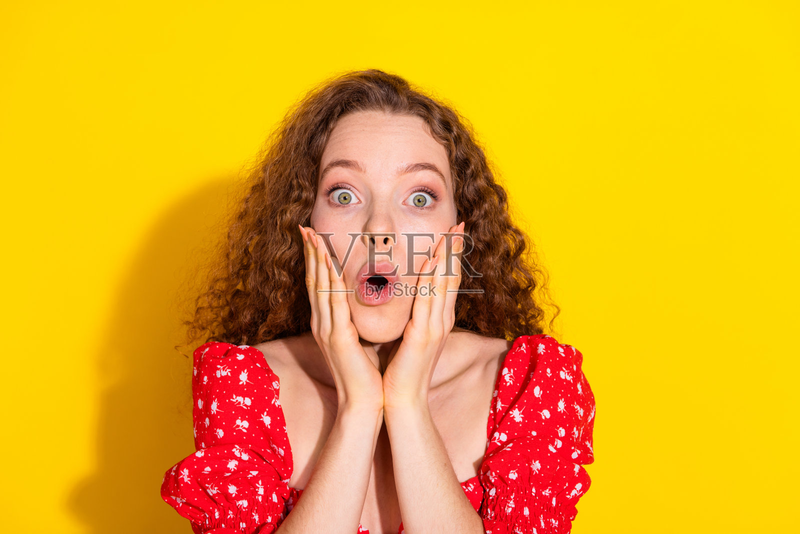 可爱的女孩穿着红色上衣，双手托着脸颊，背景为黄色，空白处留白。照片摄影图片