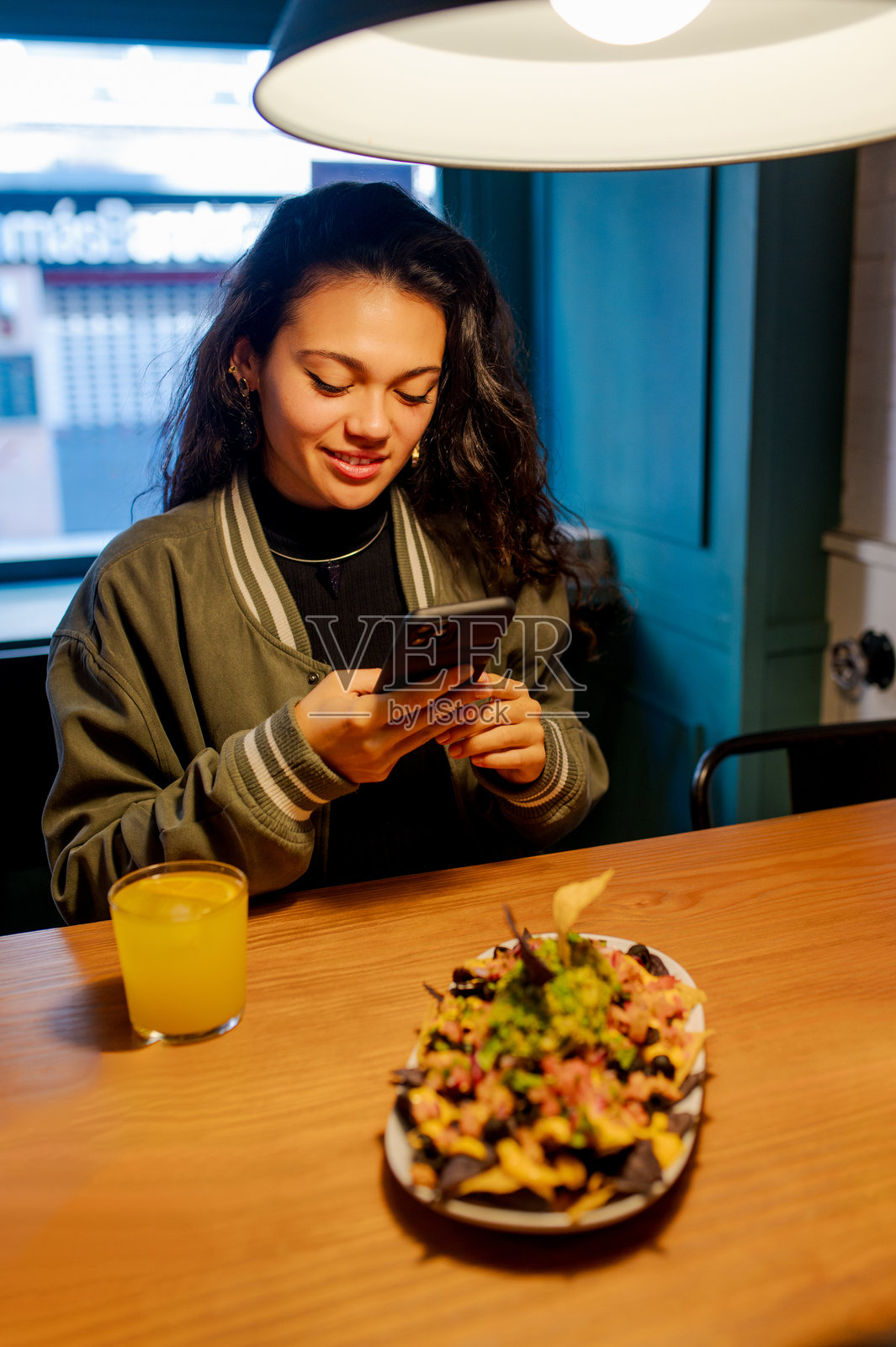年轻女性在拍摄她的食物照片摄影图片