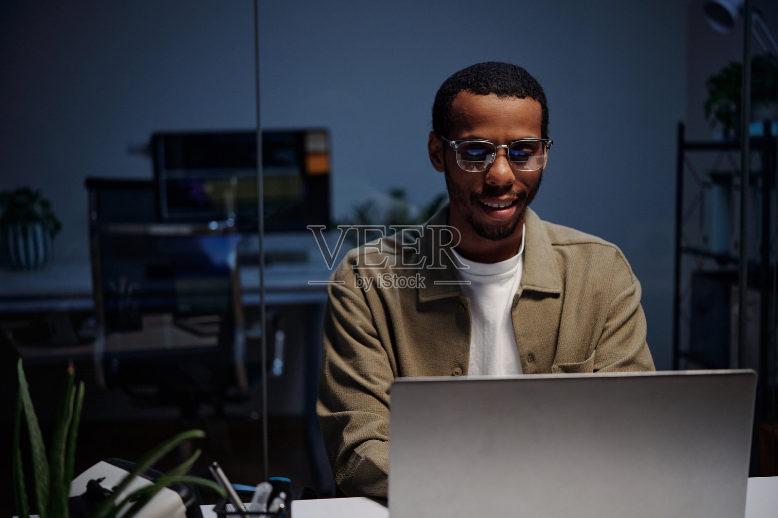 现代办公室中微笑的男子在使用笔记本电脑的肖像照片摄影图片