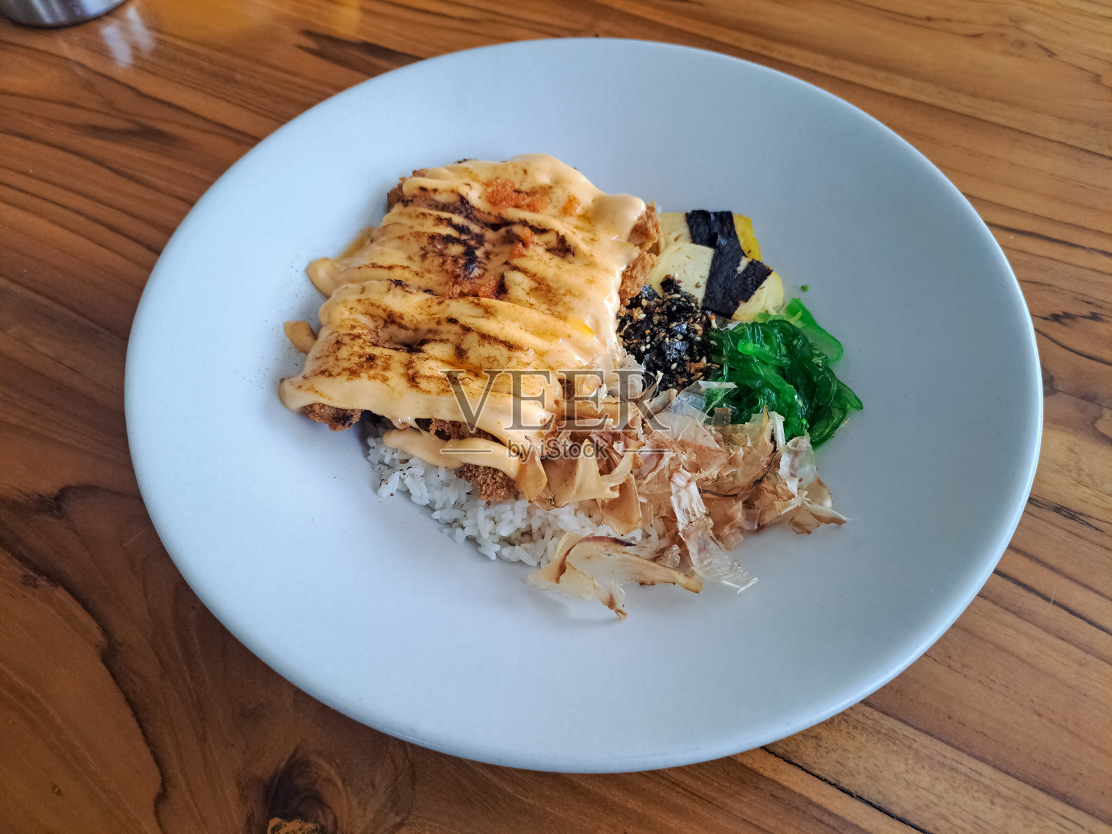 美味的脆皮明太子鸡配黄油饭、鸡排、明太子酱、海苔、鸡蛋、鲣鱼片、飞鱼卵、凉拌海带。菜单。照片摄影图片