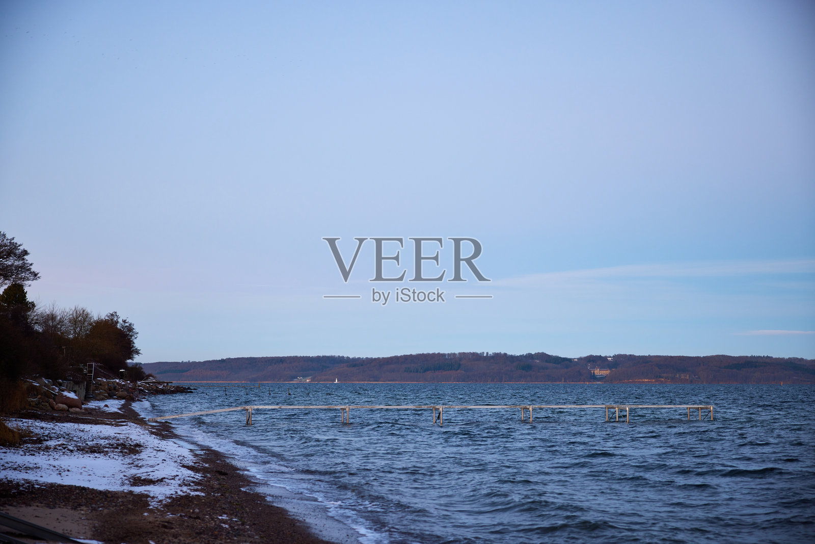 阳光明媚的日子里，海景前的金属码头照片摄影图片