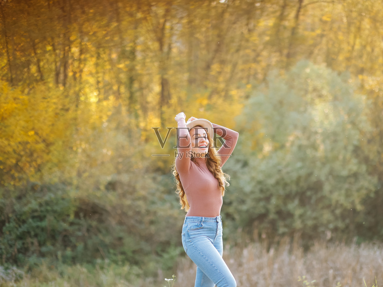 美丽的女人在阳光明媚的秋日中尽情享受照片摄影图片