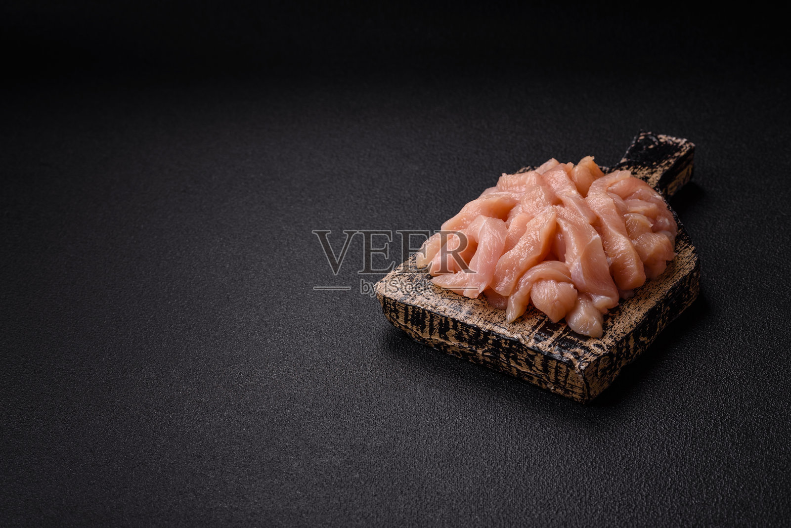 切成条状的生鸡胸肉，撒上香料和草药照片摄影图片