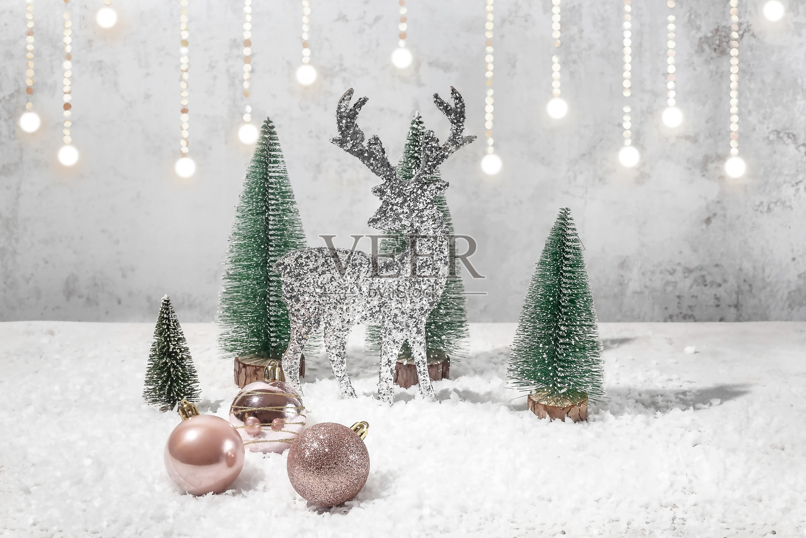 银色圣诞鹿雕像、圣诞球和圣诞树，背景为浅色并带有金色边缘照片摄影图片