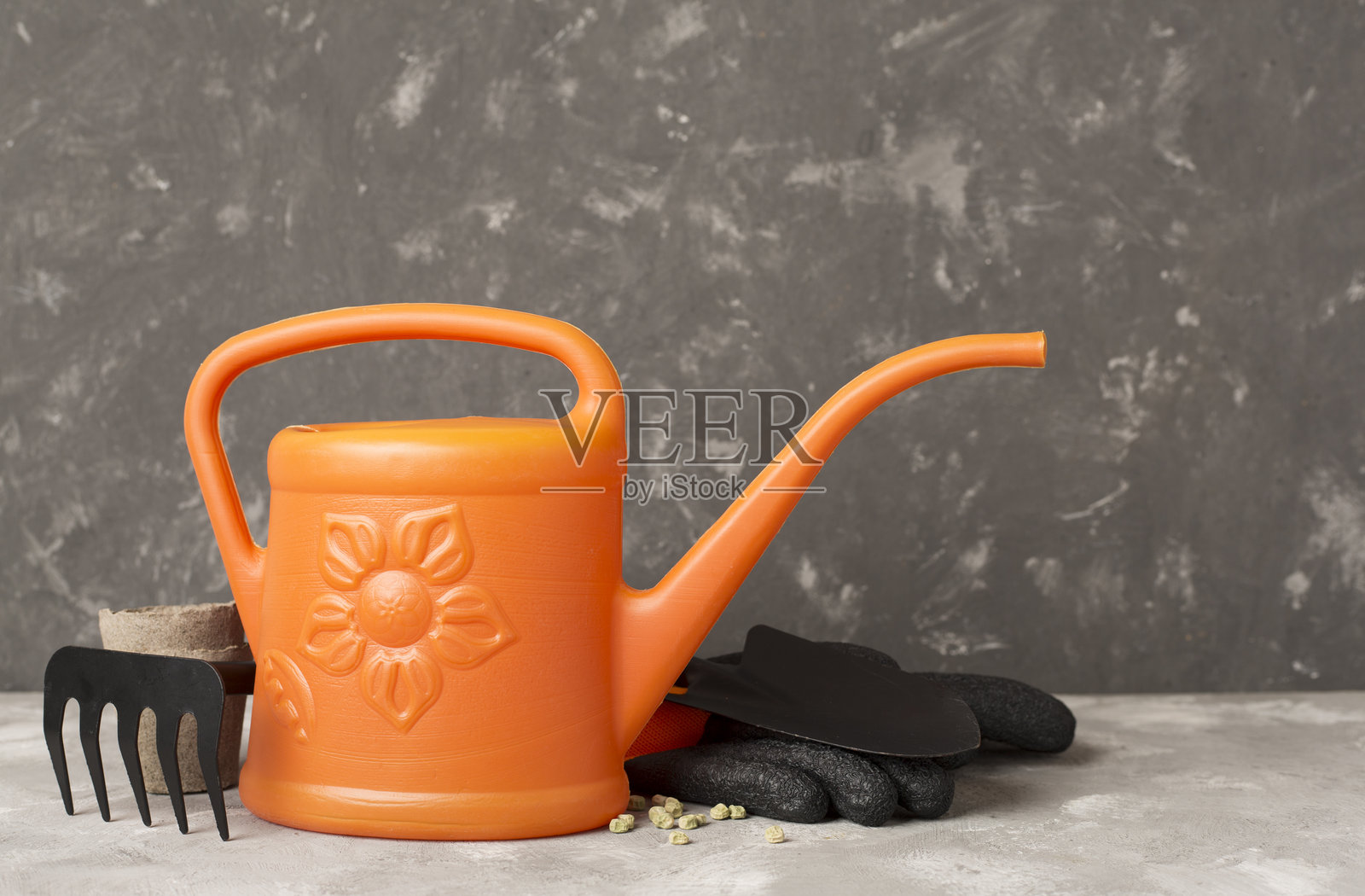浇水壶和园艺工具放在混凝土背景上照片摄影图片