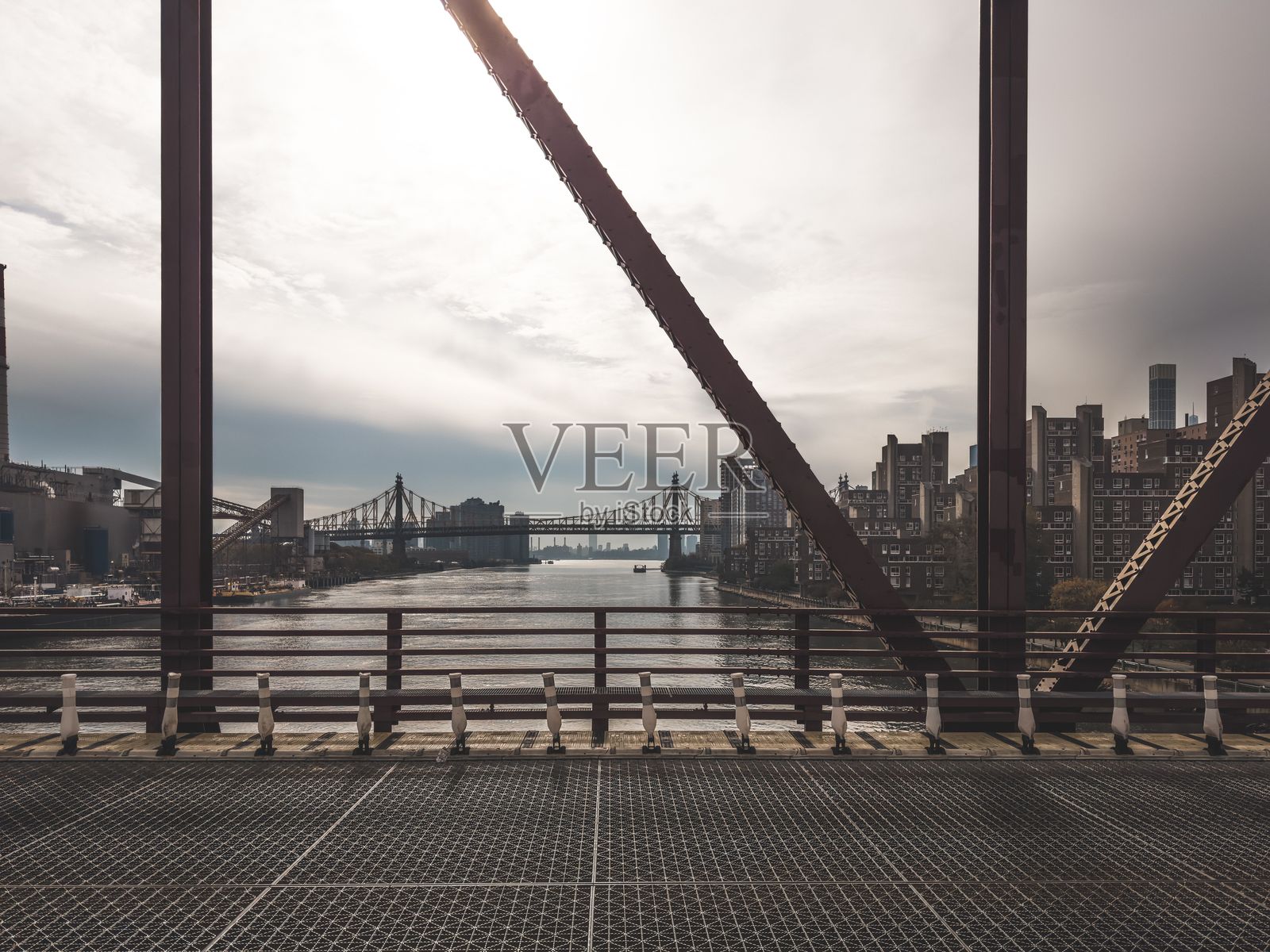 高楼大厦环绕的纽约市桥梁，远处天边云层密布。照片摄影图片