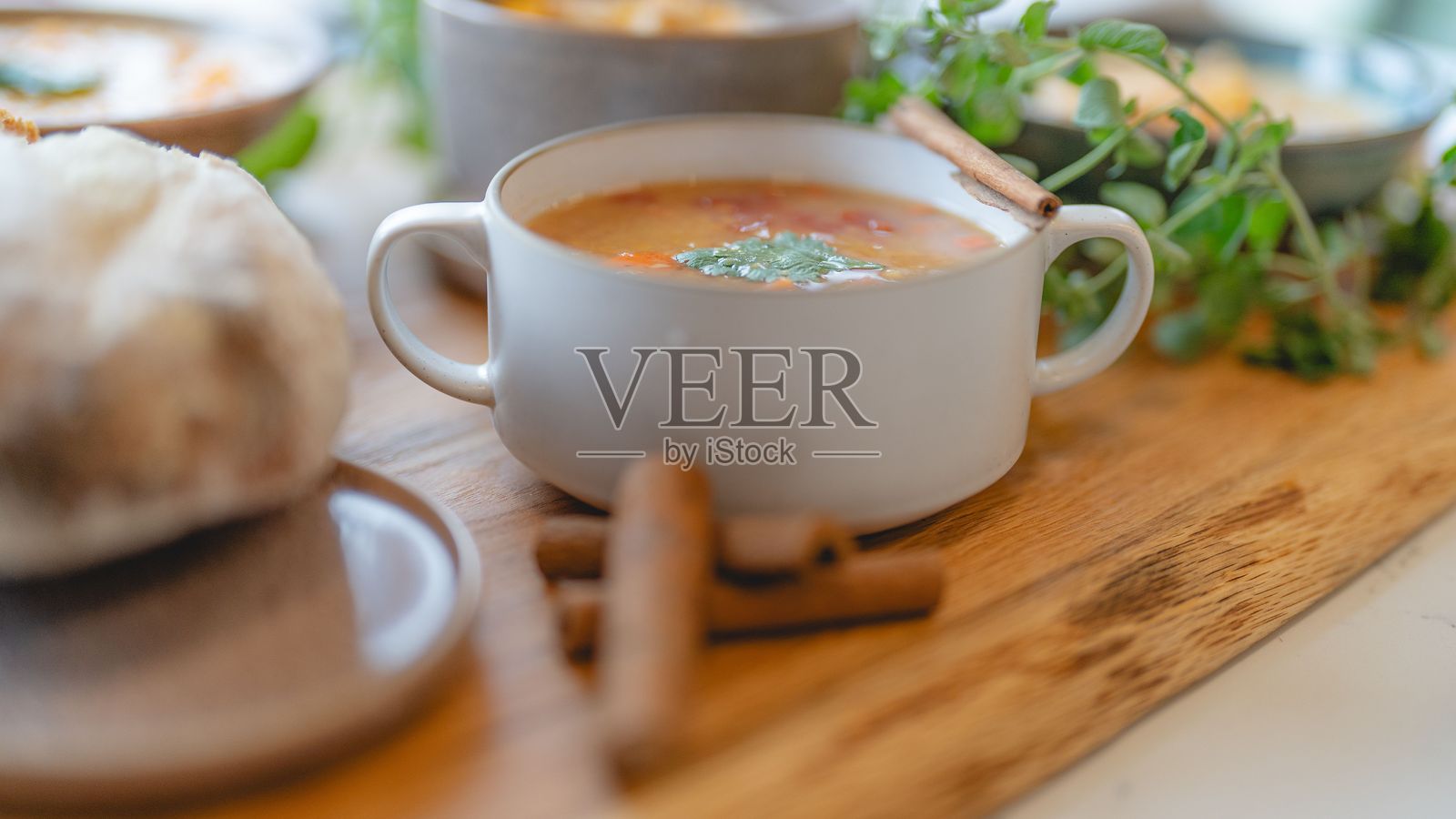 木桌上的汤、面包和一些绿色蔬菜照片摄影图片