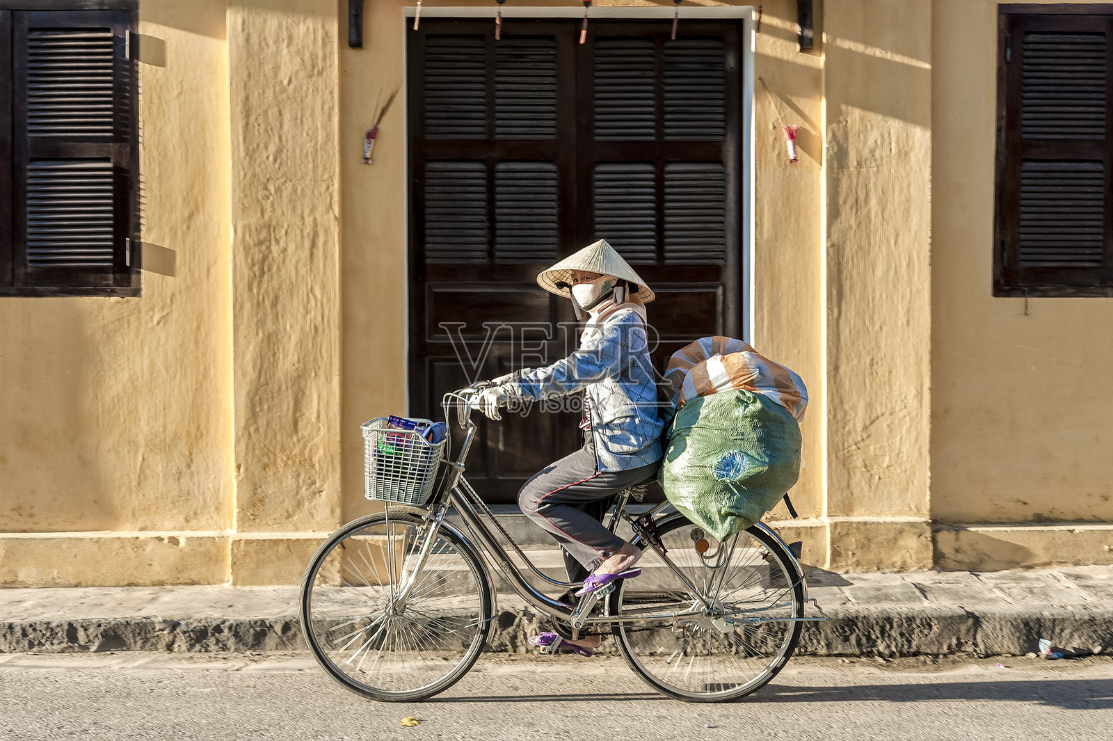 越南女性骑着重载自行车行驶照片摄影图片