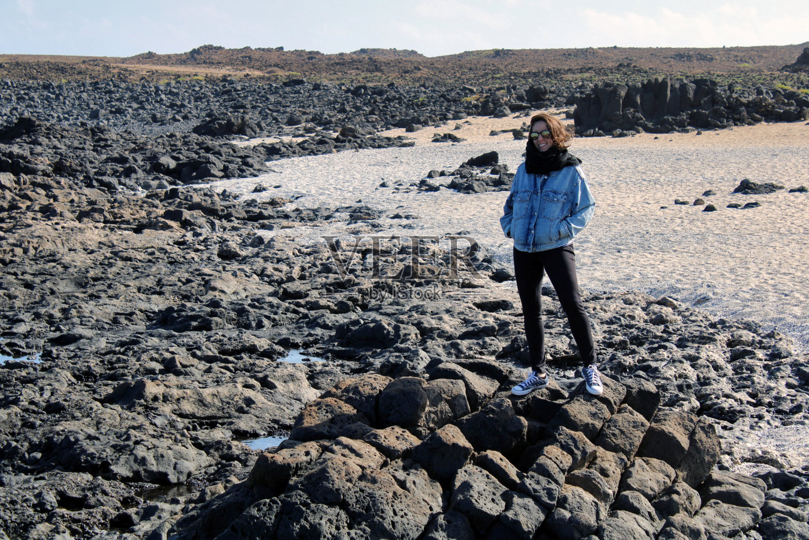在遥远背景的岩石景观中站着的人照片摄影图片
