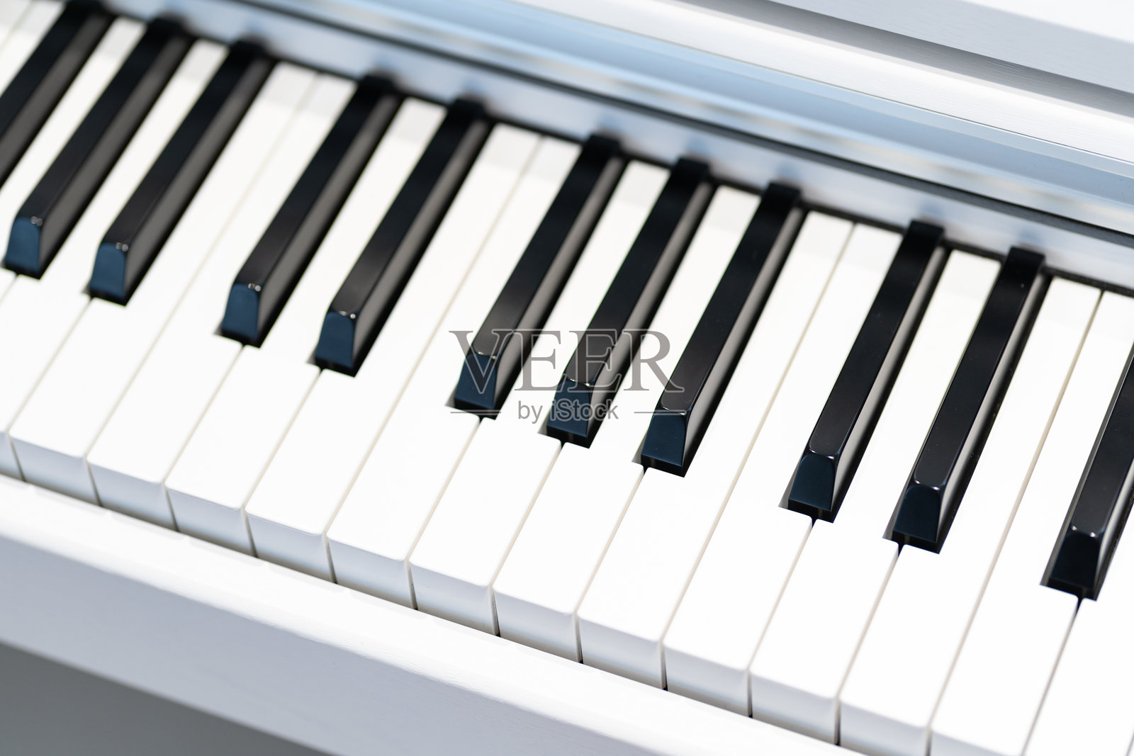 白色电子钢琴上的黑白琴键。钢琴键特写。经典钢琴键盘。照片摄影图片
