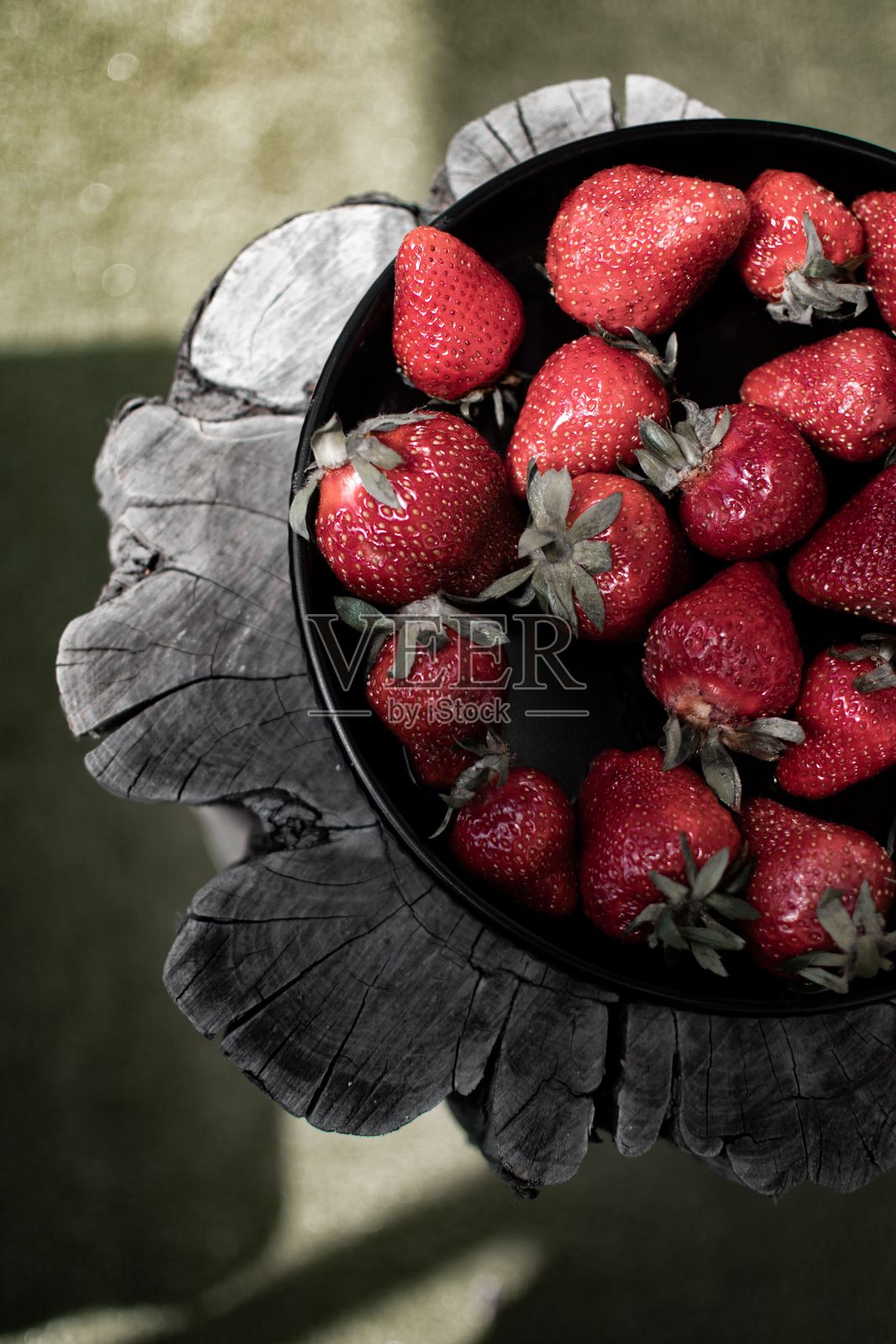 一碗新鲜的草莓放在古朴的木桌上照片摄影图片