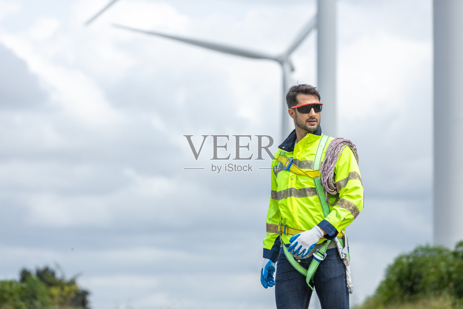 工程师们手持工具箱和绳索，在风力涡轮机上进行维护工作。可再生能源风力涡轮机。技术保护环境，减少全球变暖问题。照片摄影图片