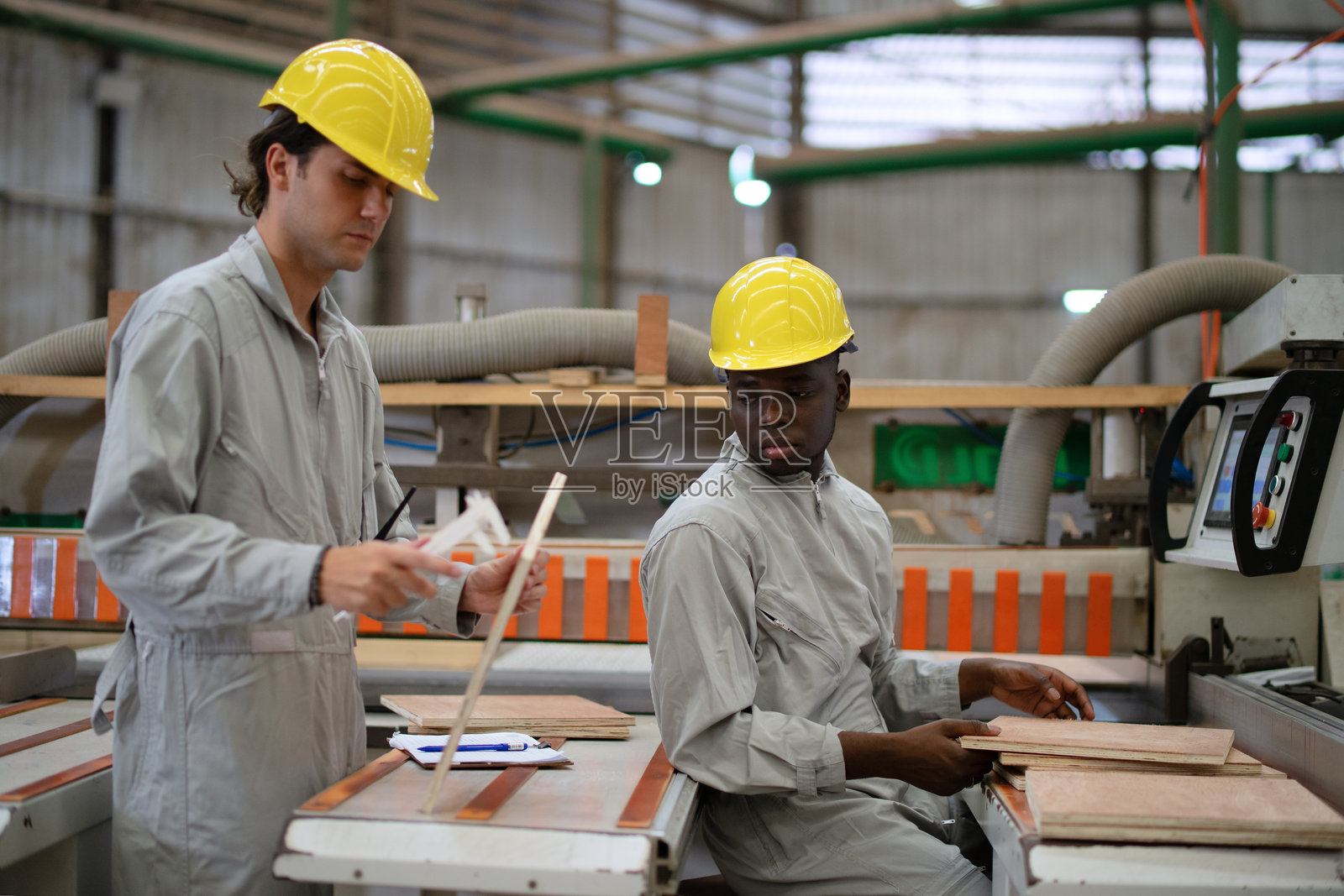 蓝领工人在木材厂工作。照片摄影图片