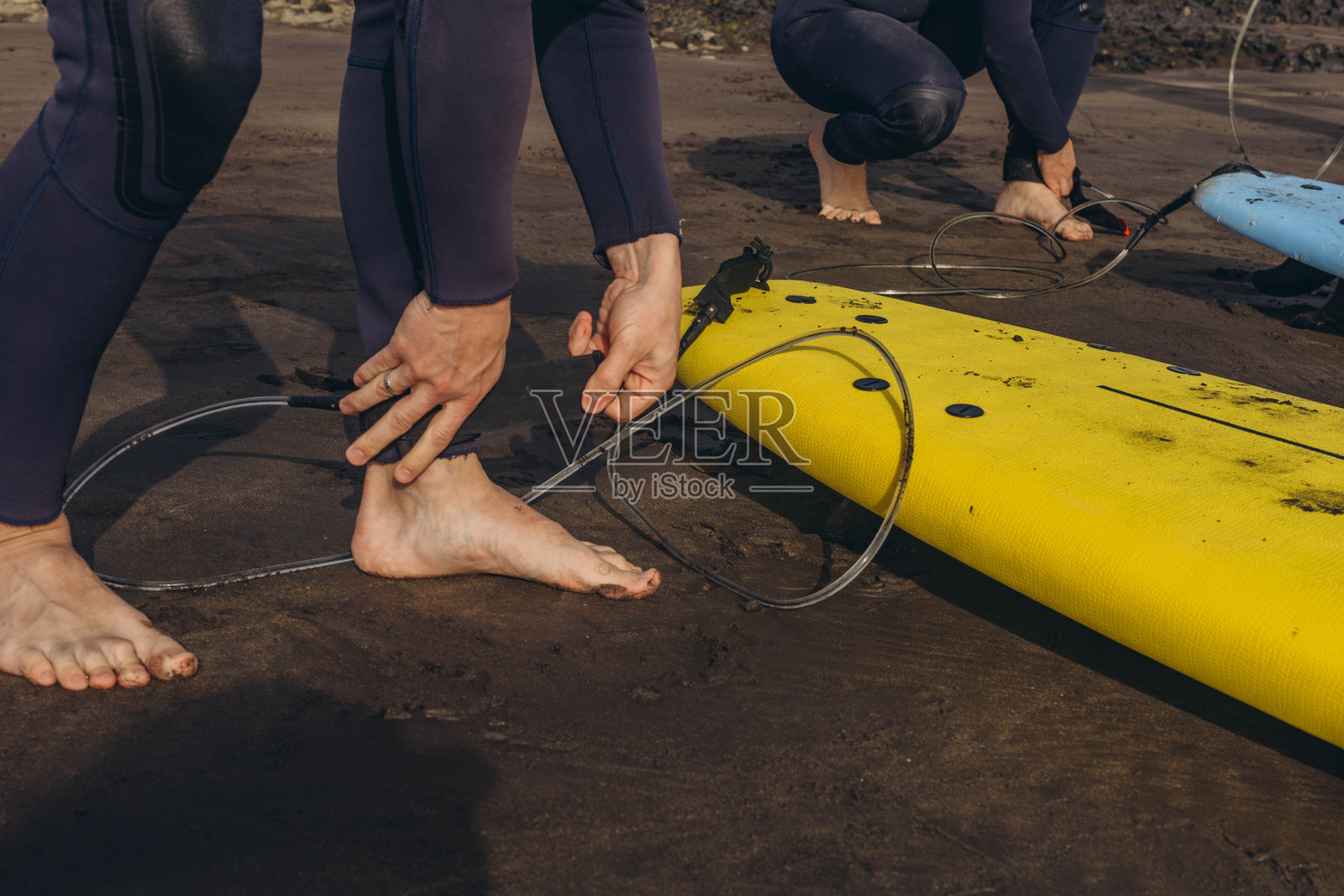 教练向一群冲浪者示范如何冲浪。沙滩上的冲浪者照片摄影图片