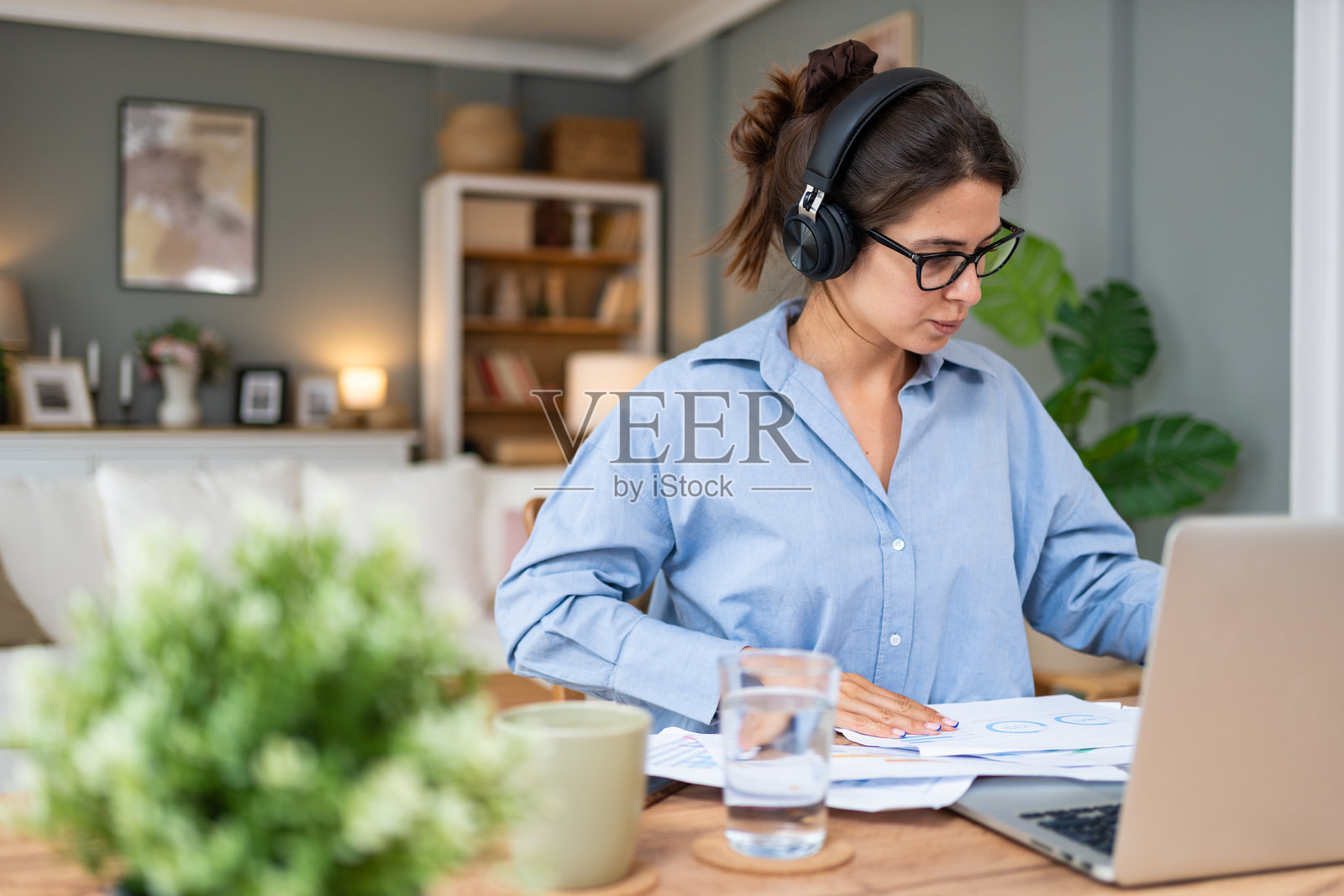 年轻专注的严肃自由职业商业专家女性在家办公室用笔记本电脑工作。金融和经济专业人士正在完成客户的计算工作。照片摄影图片