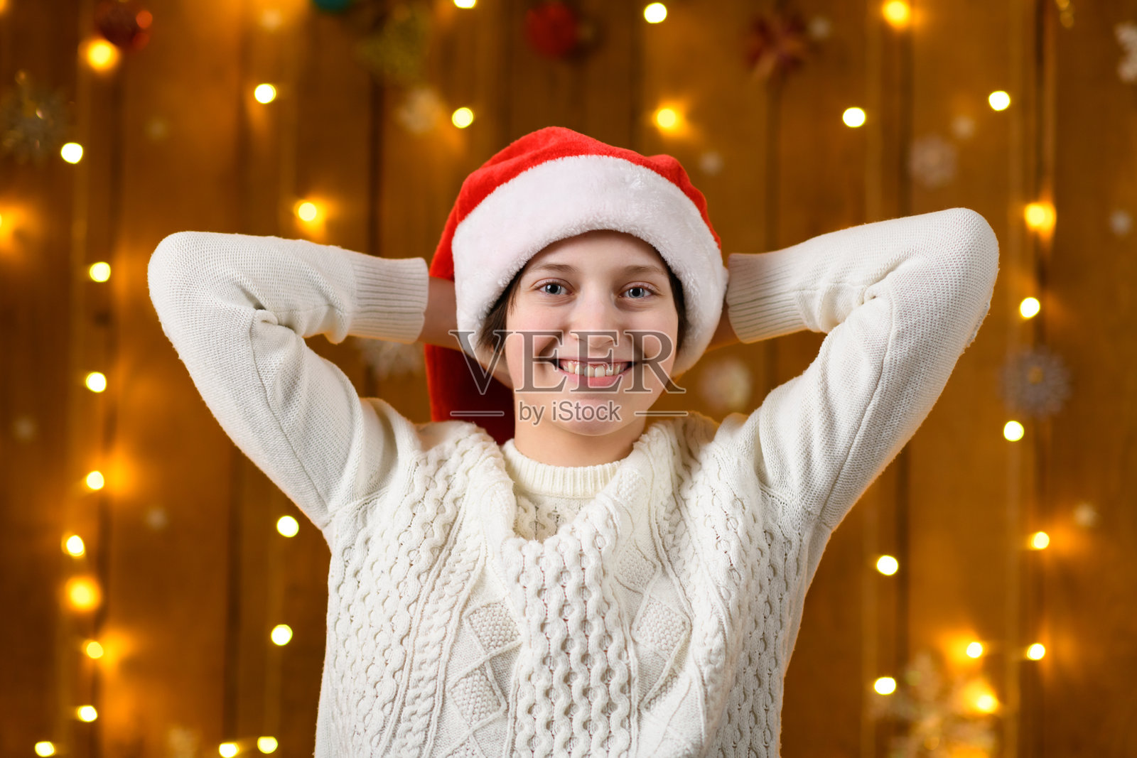 一名少女在新年节日装饰中摆姿势，节日的灯光和花环，圣诞装饰。照片摄影图片