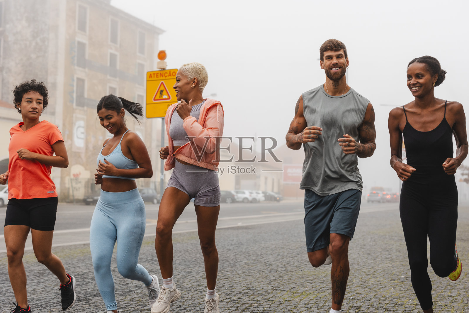 一群运动员在雾霭弥漫的城市中一起奔跑照片摄影图片
