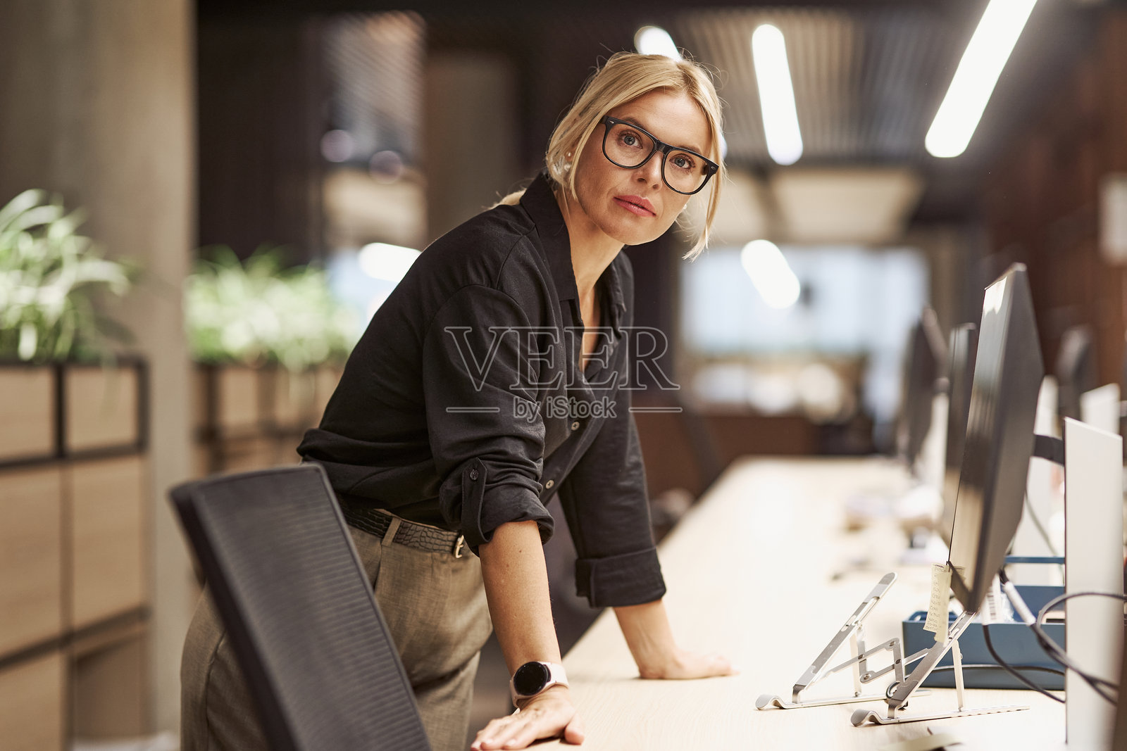 一位专业女性在时尚现代的工作空间中高效工作，追求商业成功照片摄影图片