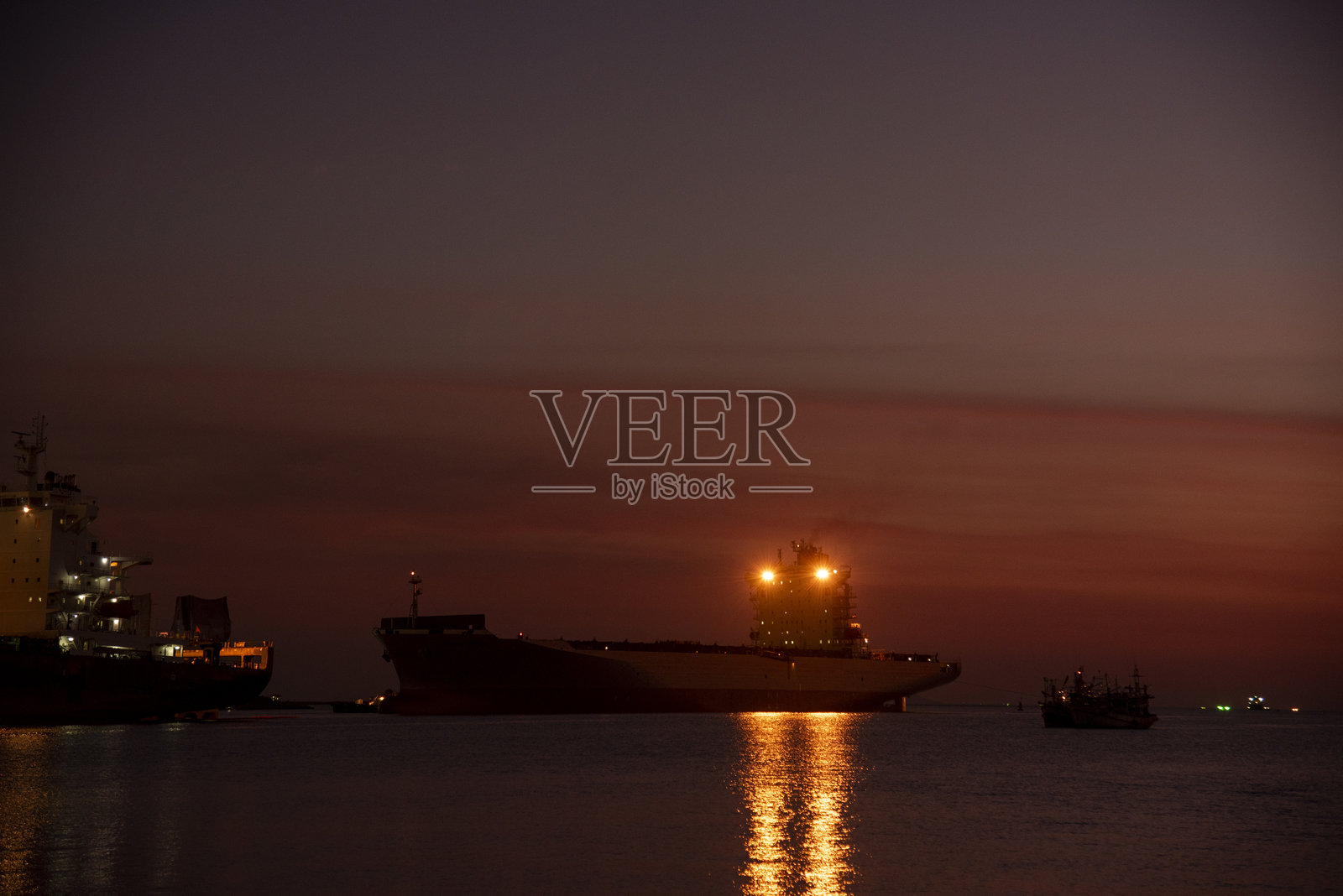 日落时分的工业景观，工程运输起重机在物流出口码头控制区。剪影仓库货运背景，集装箱场地装载码头港口，留有空白空间。照片摄影图片