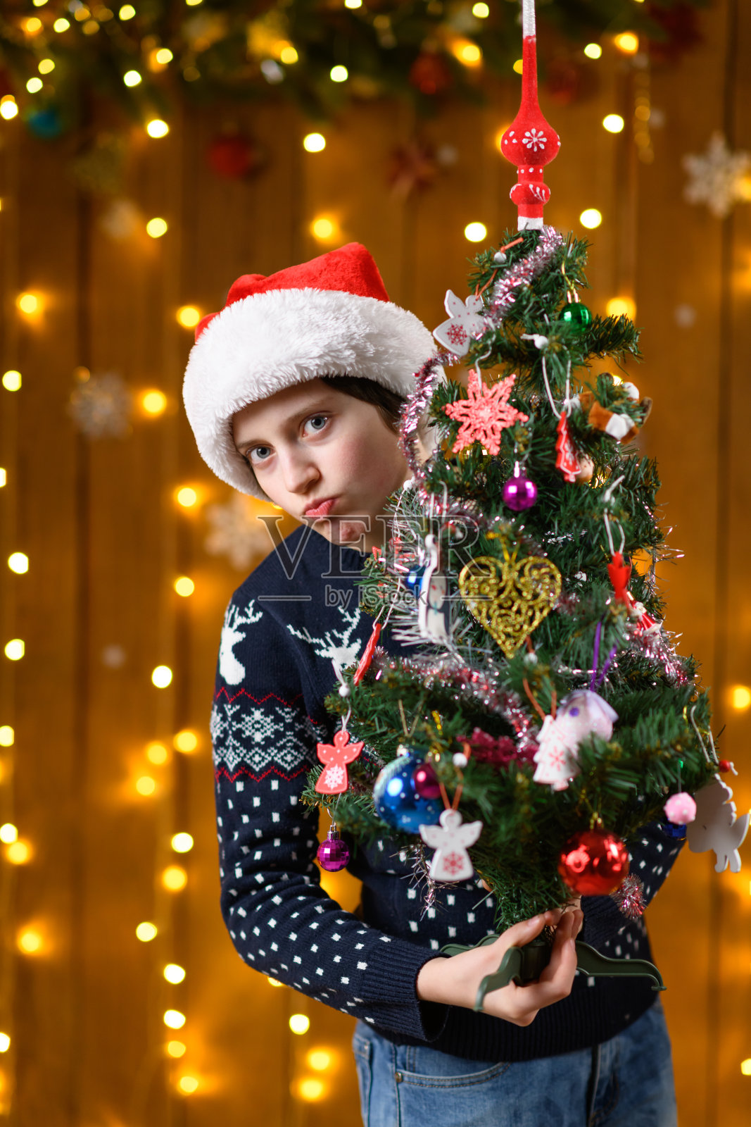 一个少女与圣诞树玩具、节日装饰、节日灯光和花环合影照片摄影图片