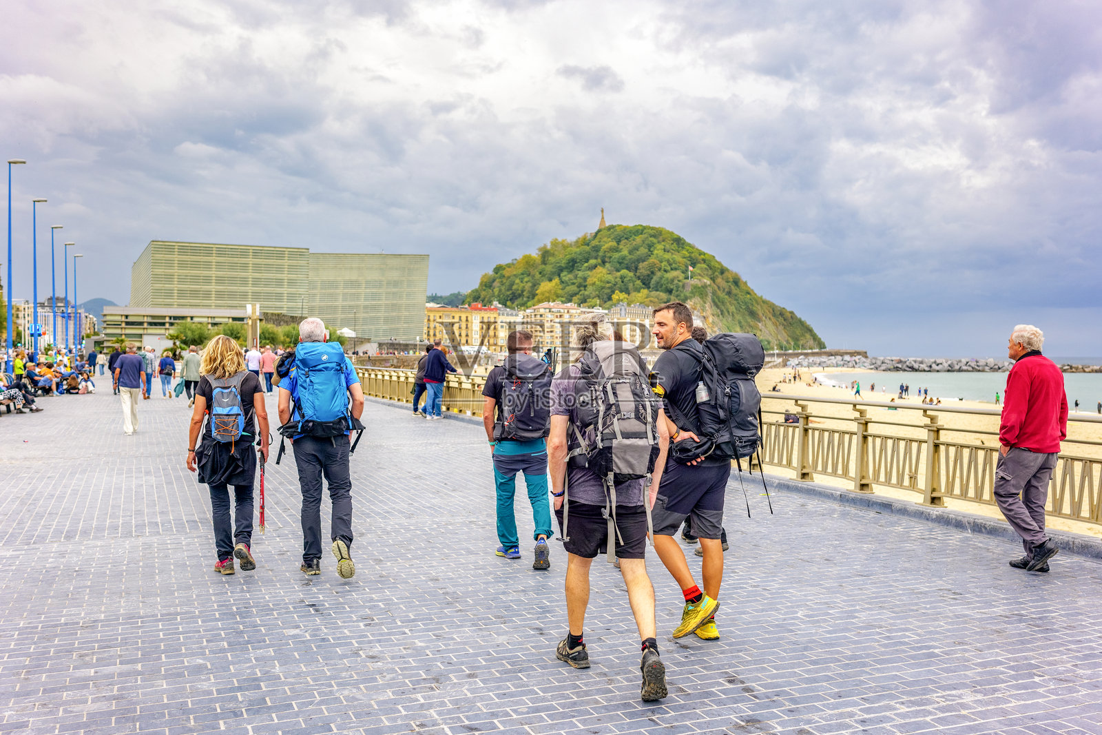 一位朝圣者在圣塞巴斯蒂安的Zurriola海滩长廊上行走，这是朝圣之路北线的一段。照片摄影图片