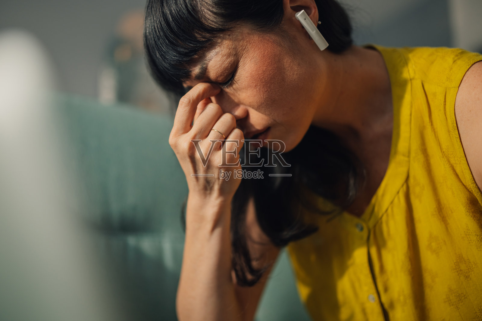 专注的亚洲女性在家中戴着耳机使用笔记本电脑工作照片摄影图片