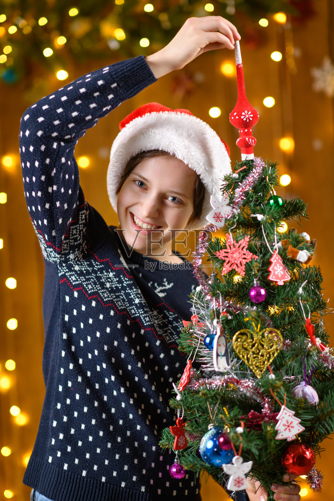 一个少女与圣诞树玩具、节日装饰、节日灯光和花环合影照片摄影图片